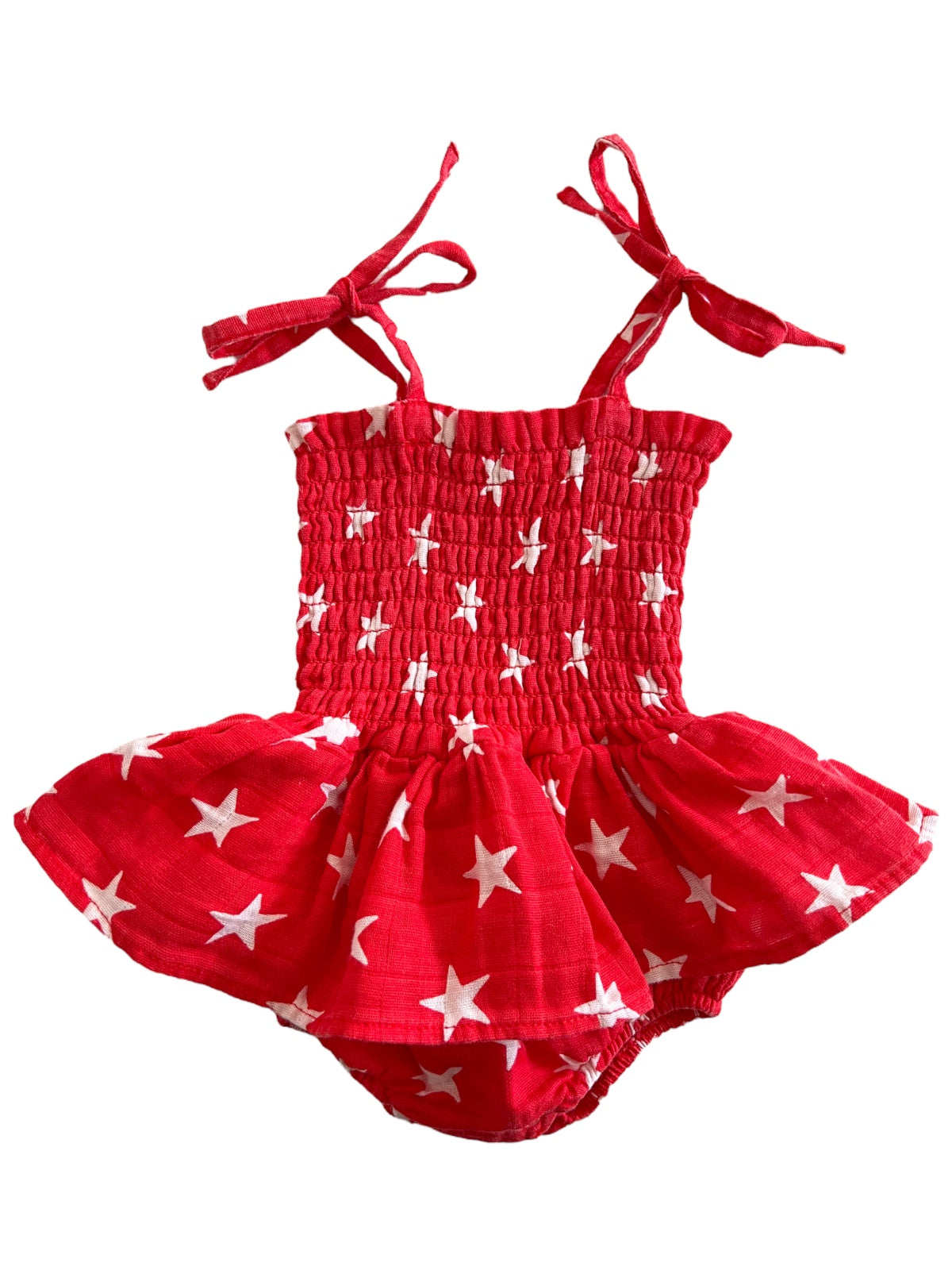 Red dress with white stars, featuring a smocked bodice and tie straps, suitable for children.