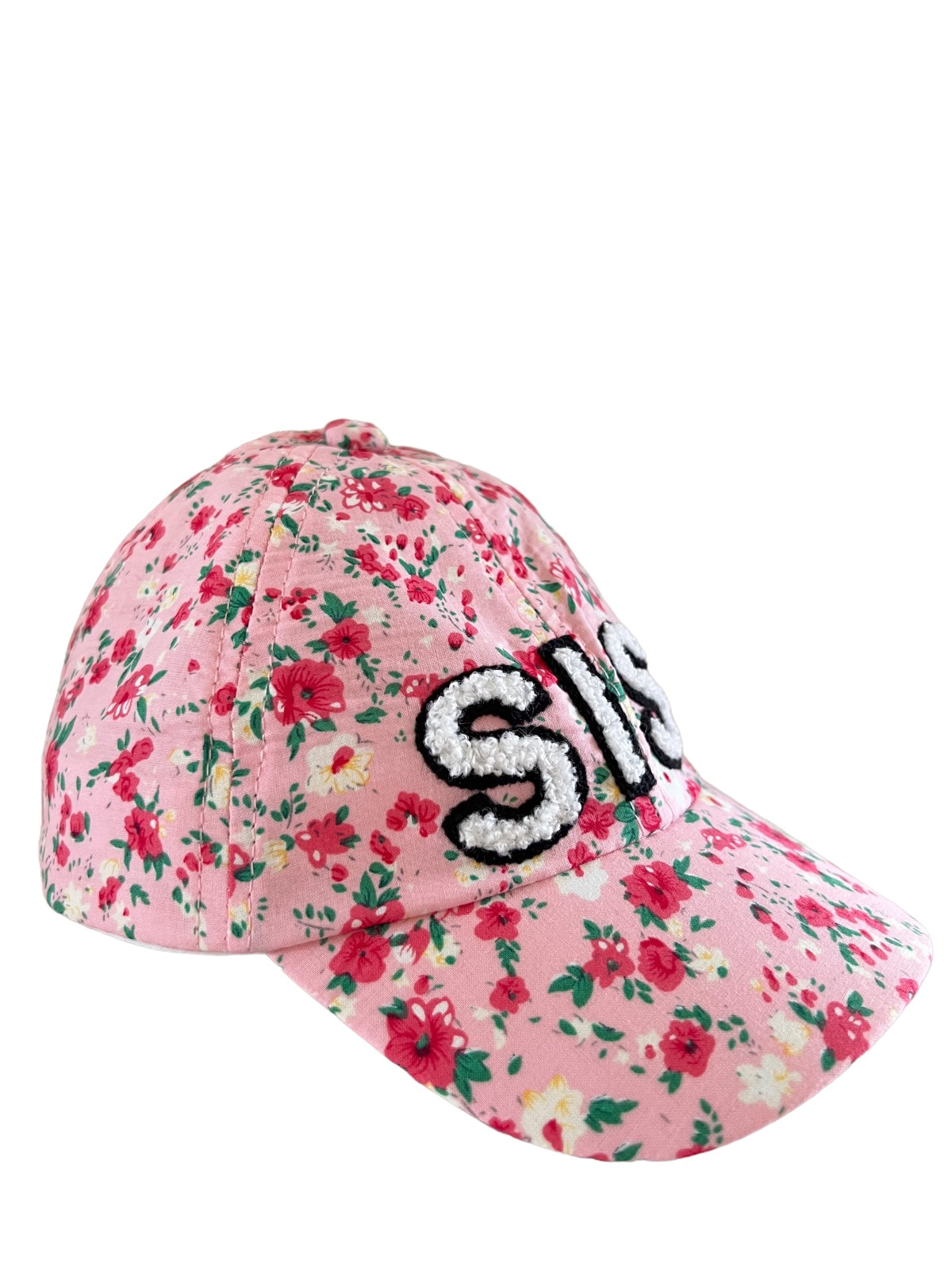 Pink floral cap with the word "SIS" embroidered on the front in black and white.