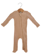 Beige baby onesie on a wooden hanger with long sleeves and a front zipper.