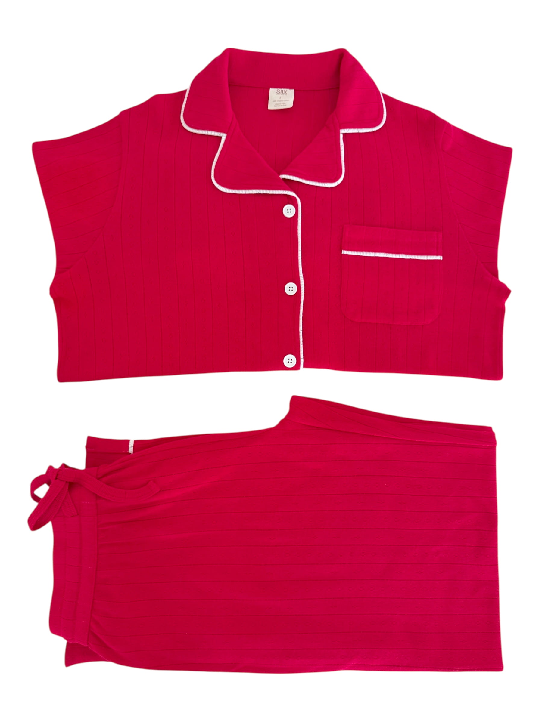 Pink pajama set featuring a short-sleeve top with buttons and a matching tie-waist skirt.