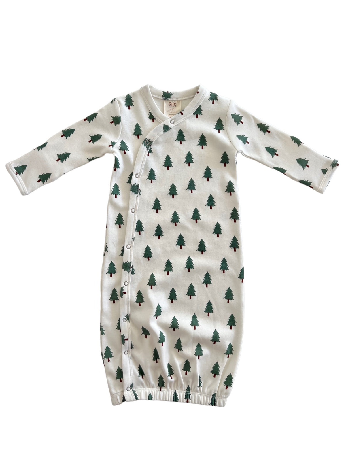 Infant gown with green tree print on white fabric, featuring long sleeves and snap closures.