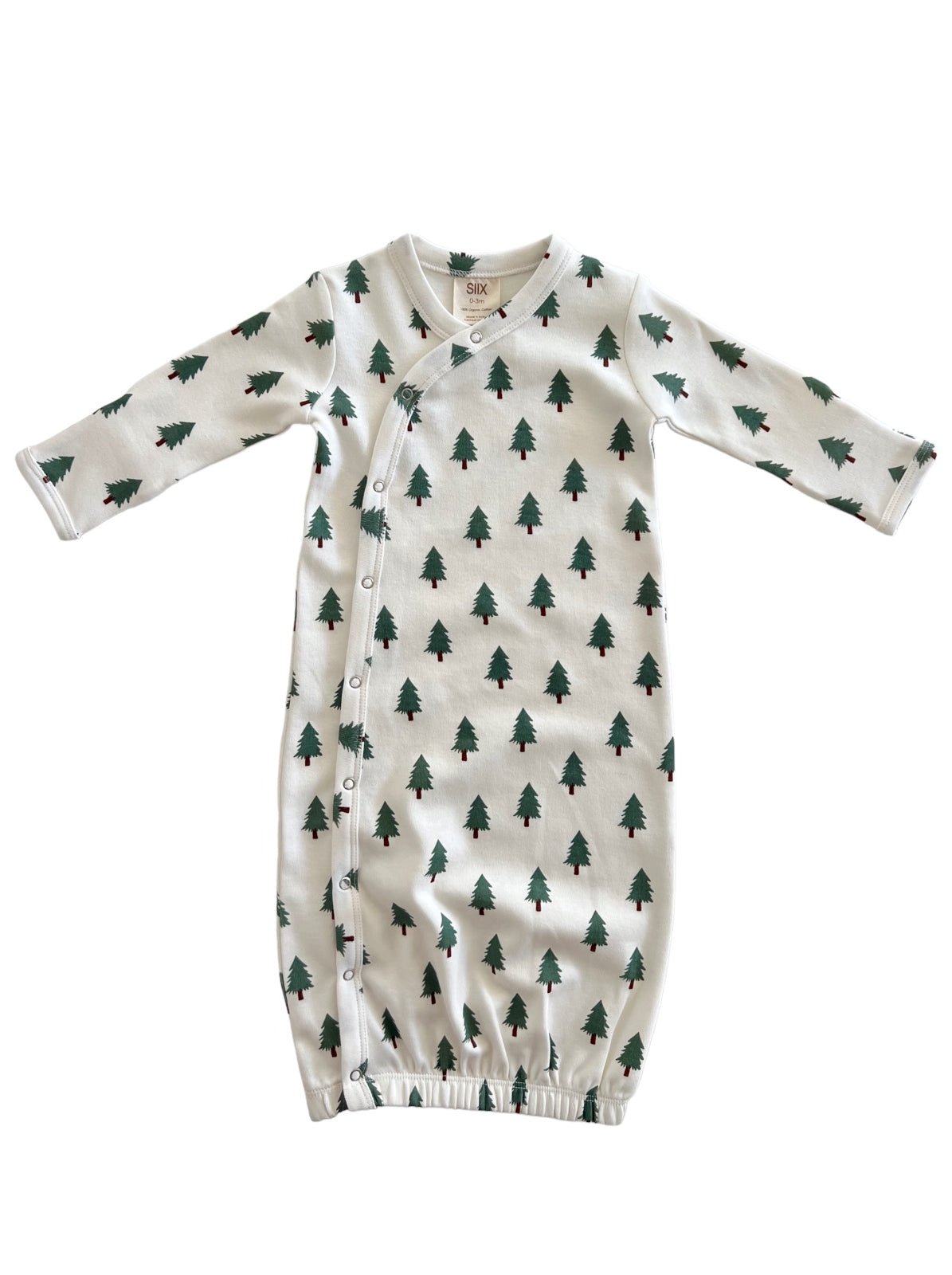 Infant gown with green tree print on white fabric, featuring long sleeves and snap closures.