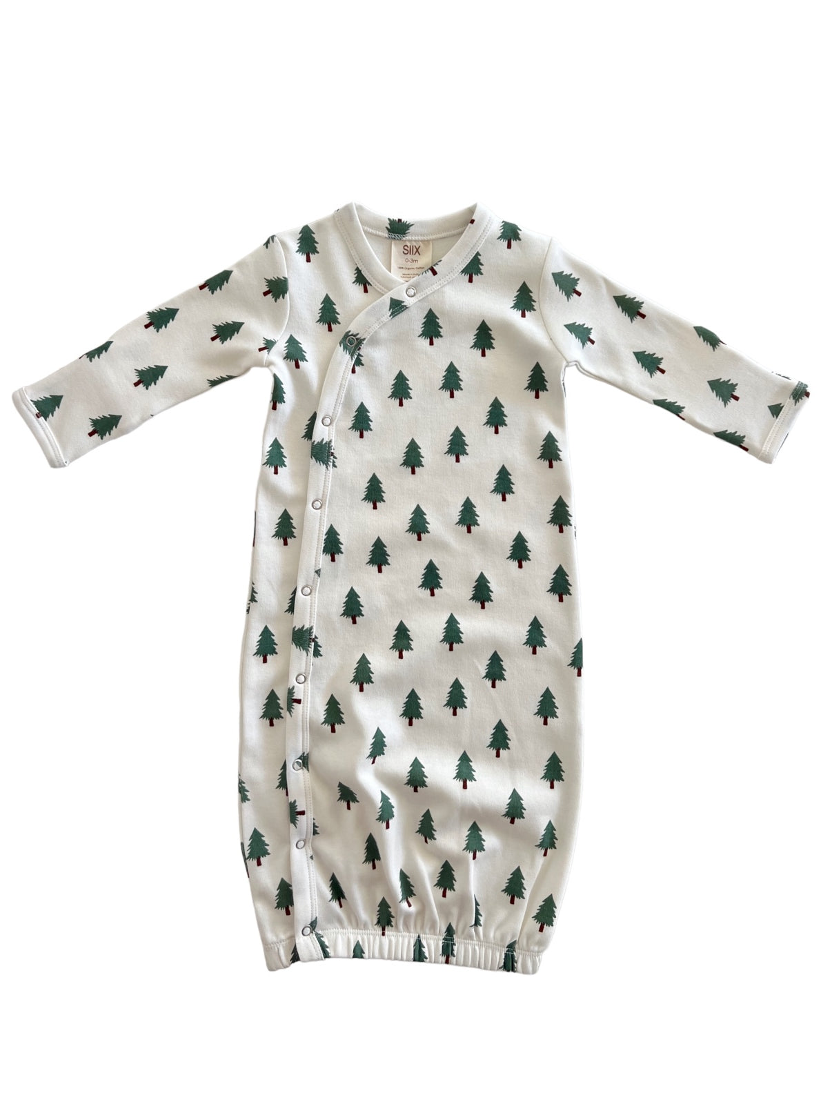 Infant gown with green tree print on white fabric, featuring long sleeves and snap closures.