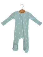 Light blue baby onesie with moon prints, featuring long sleeves and footed design, hanging on a wooden hanger.