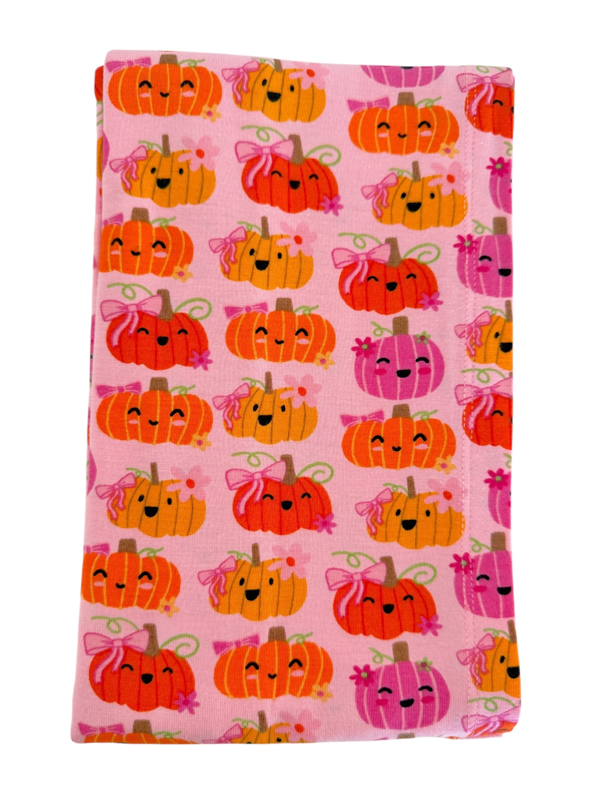 Pink fabric covered with cute, smiling pumpkins in various colors and designs. Perfect for fall-themed projects.