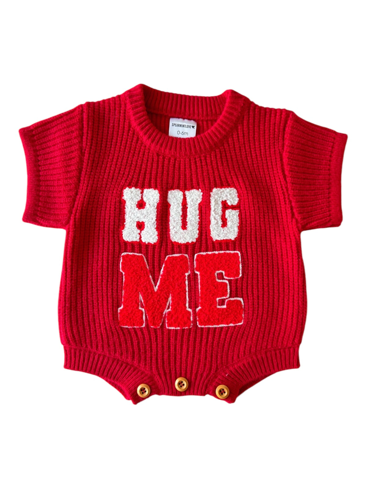 Red knit onesie with "HUG ME" text in white, short sleeves, and three button closure at the bottom.