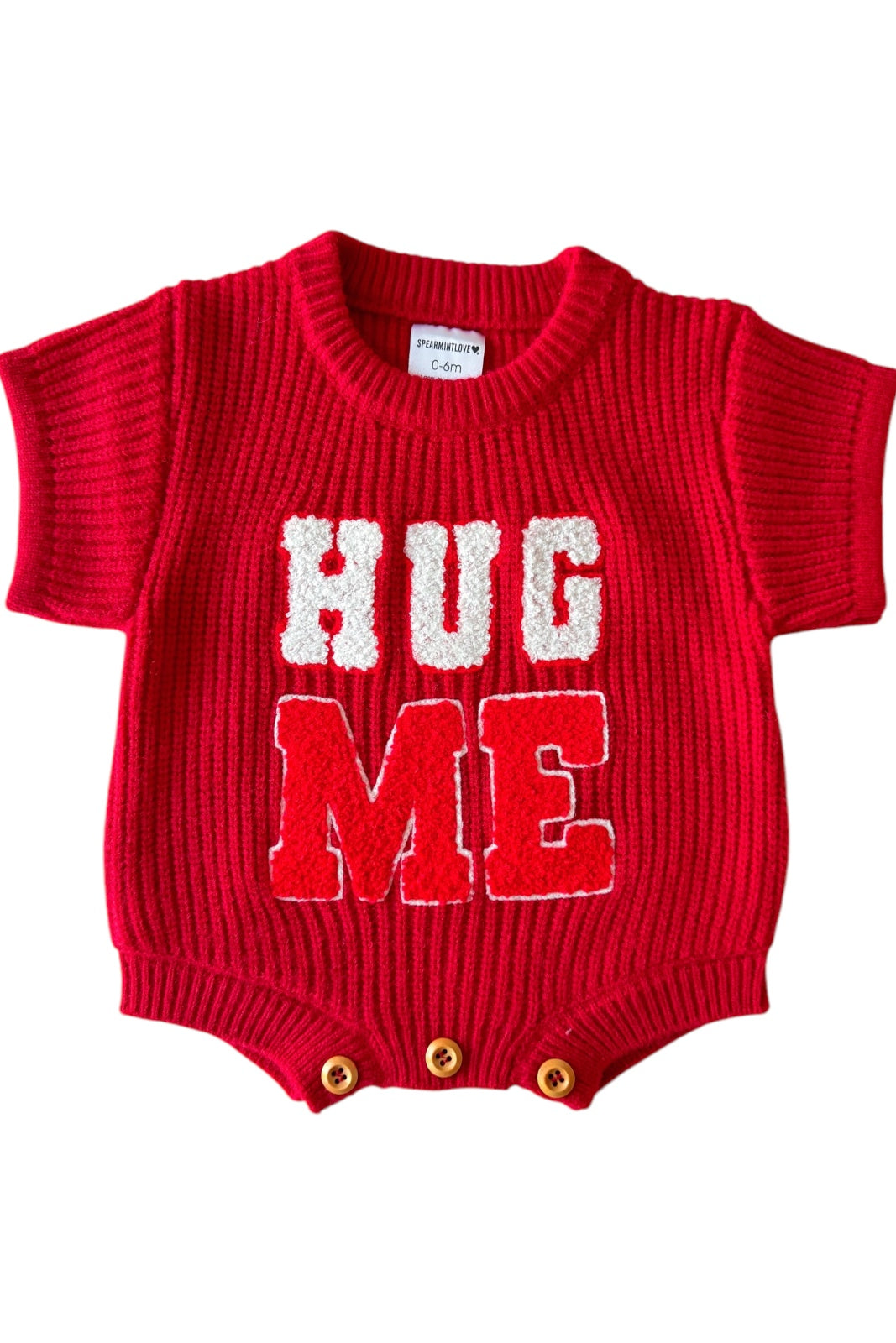 Red knit onesie with "HUG ME" text in white, short sleeves, and three button closure at the bottom.