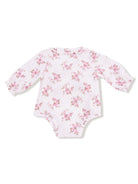 Long-sleeve baby bodysuit with floral pattern on white background and polka dots, featuring a rounded collar.