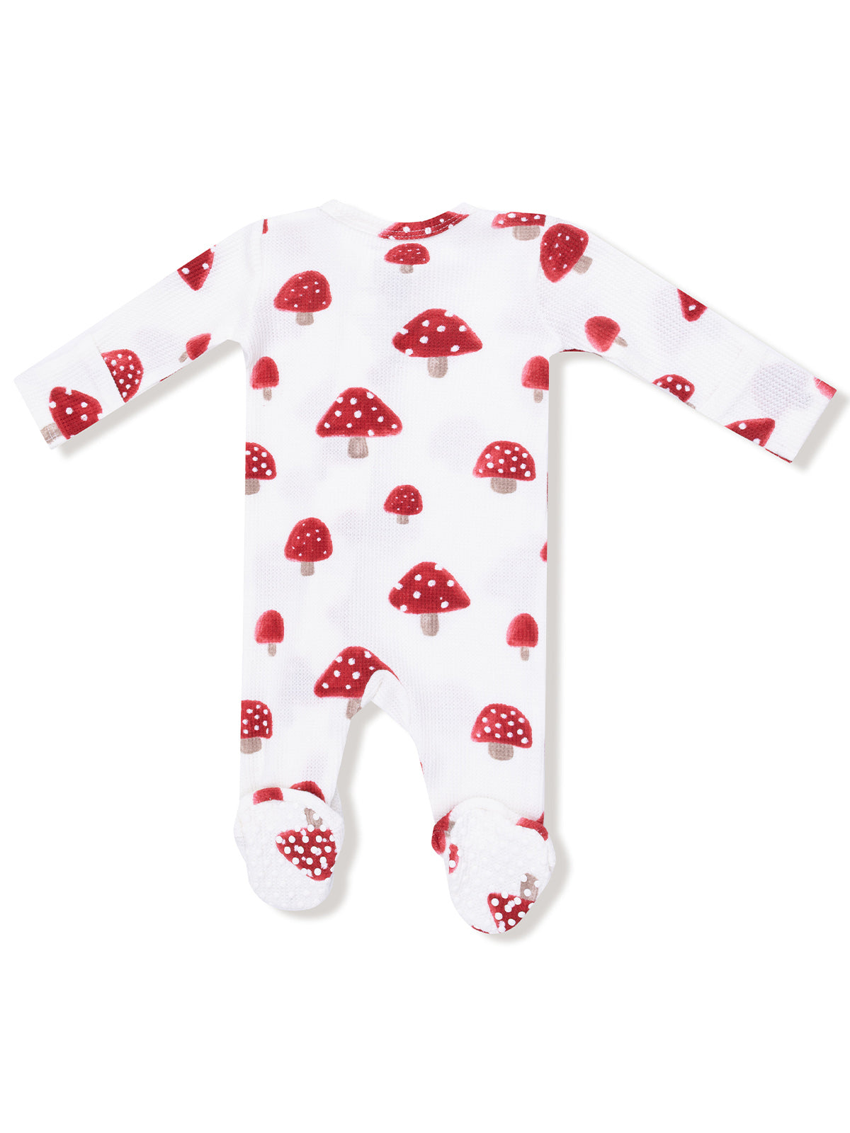 White baby onesie with red mushroom pattern, featuring long sleeves and footed bottoms.