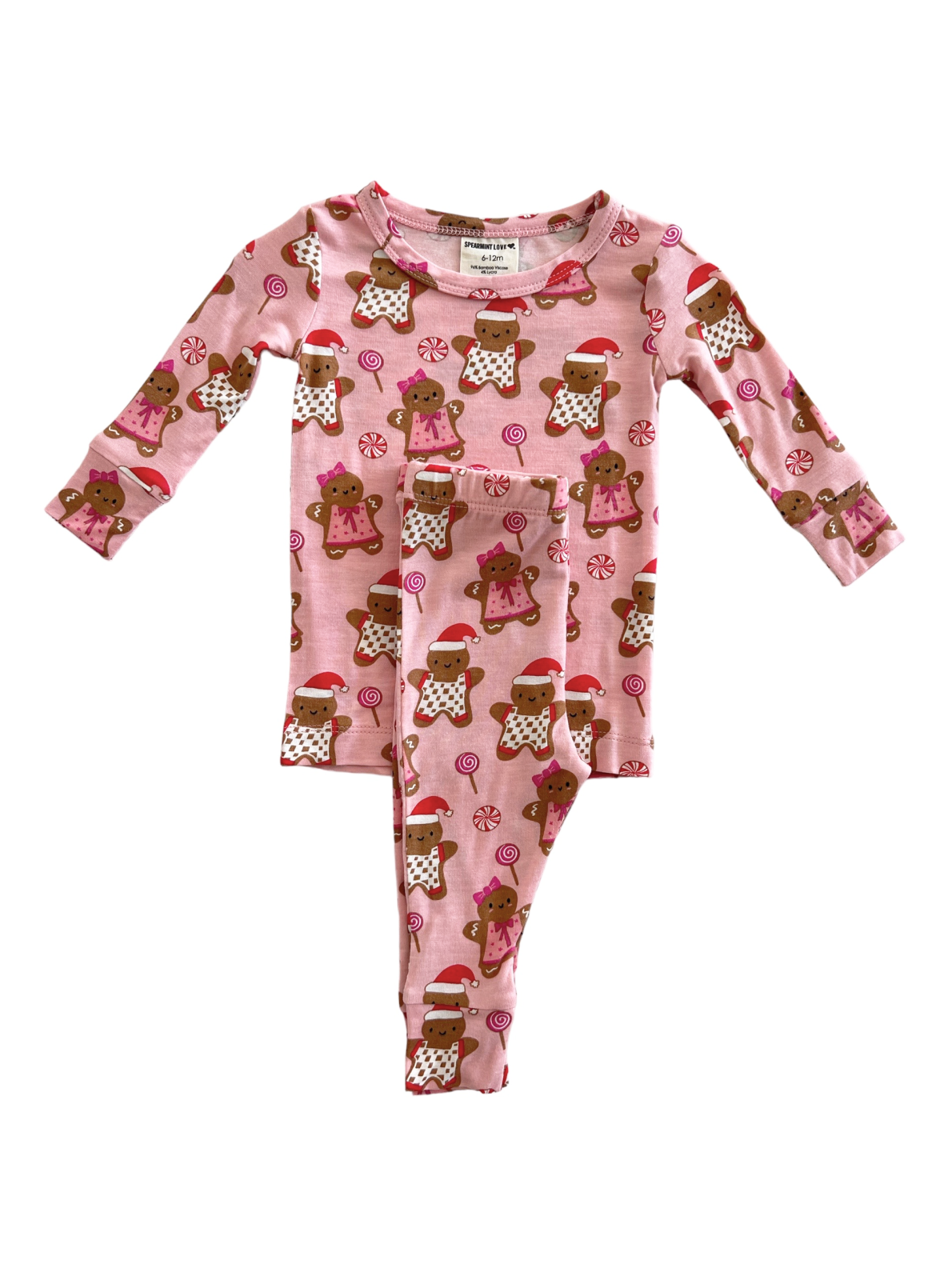 Pink pajama set featuring gingerbread cookies and candy illustrations, ideal for holiday celebrations.