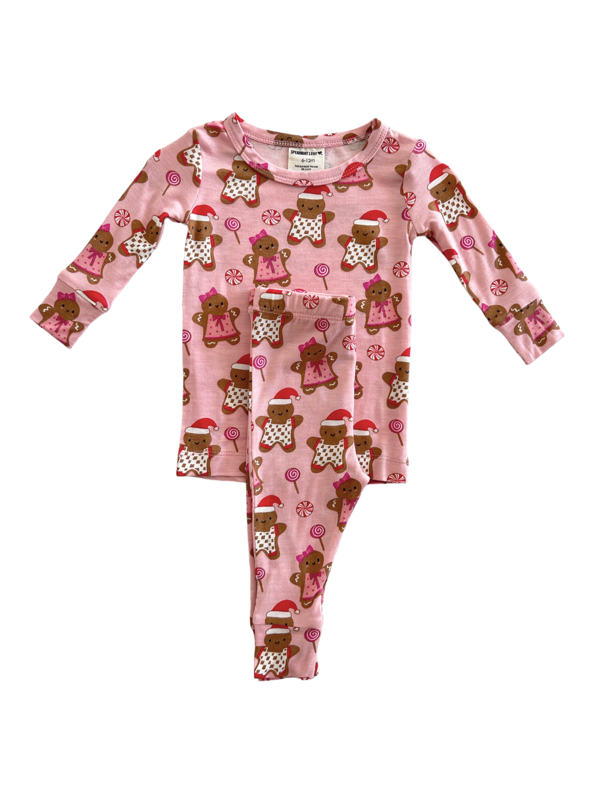 Pink pajama set featuring gingerbread cookies and candy illustrations, ideal for holiday celebrations.