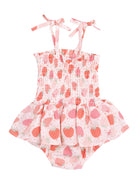 Girls' pink dress with strawberry print and tie straps, featuring a frilled skirt and smocked bodice.