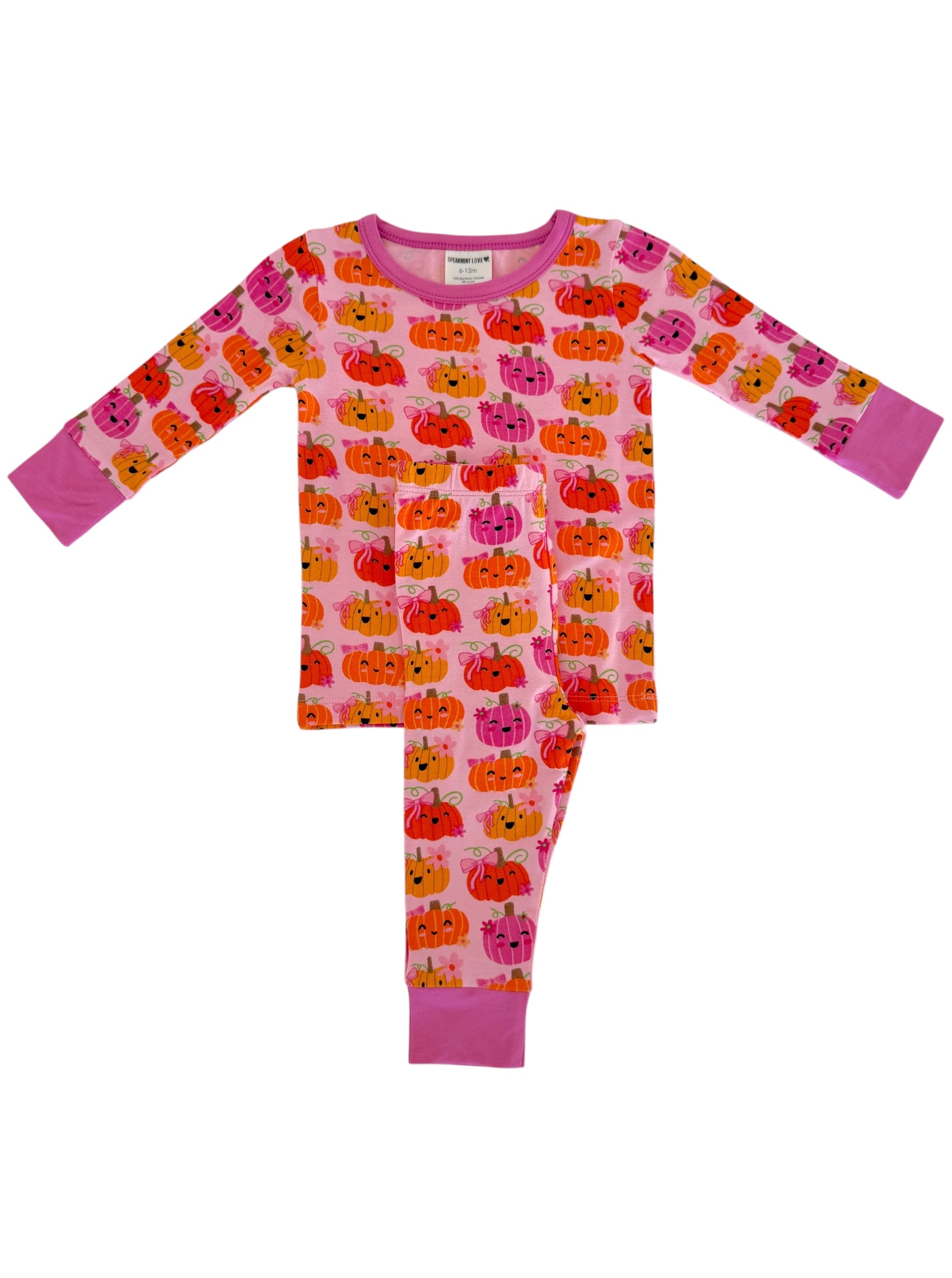 Pink pajama set with colorful pumpkin print, featuring long sleeves and pants. Perfect for cozy sleepwear.