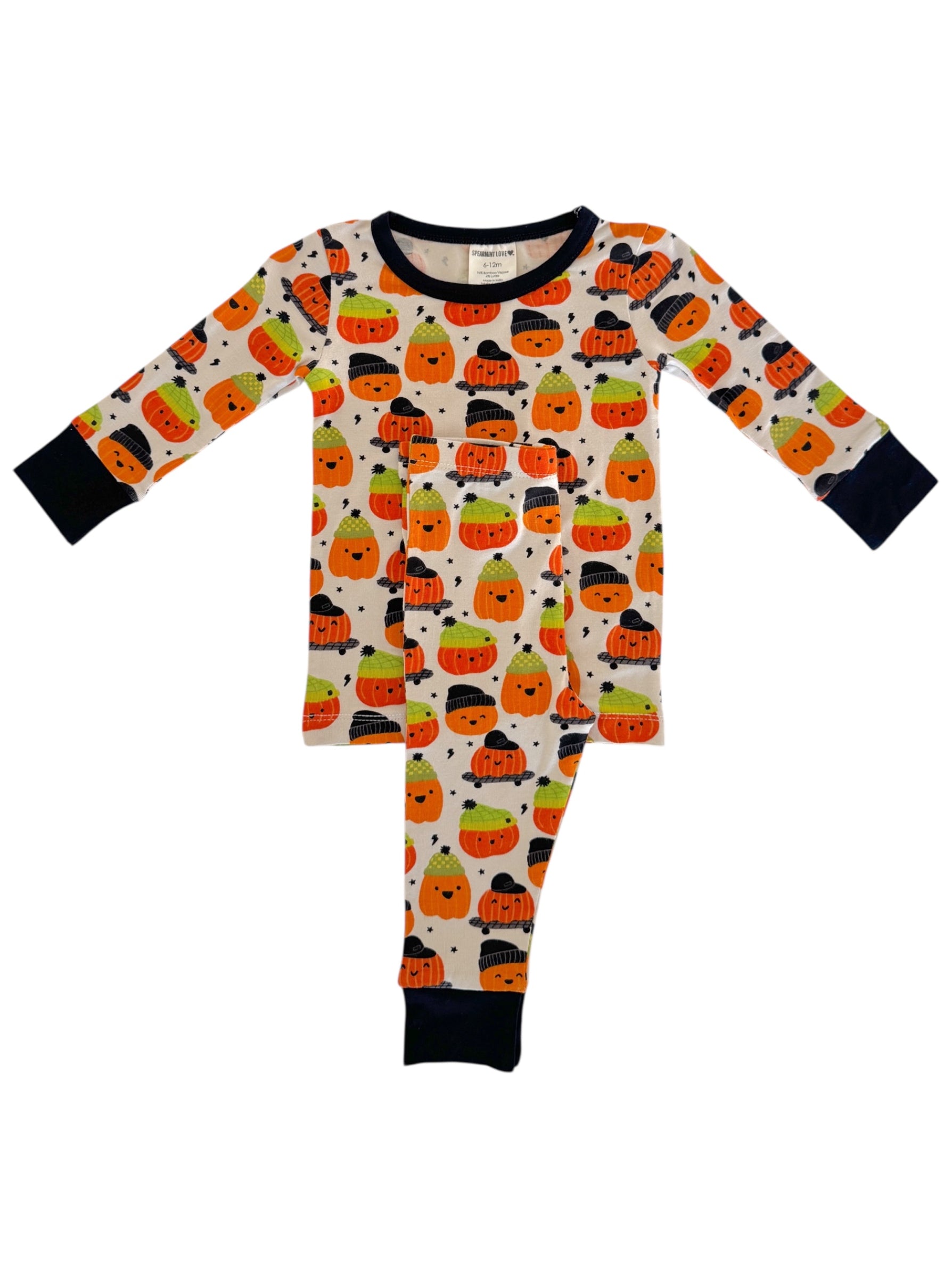Children's Halloween pajamas featuring cute pumpkin and ghost patterns in orange, green, and black on a light background.