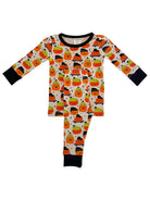 Children's Halloween pajamas featuring cute pumpkin and ghost patterns in orange, green, and black on a light background.