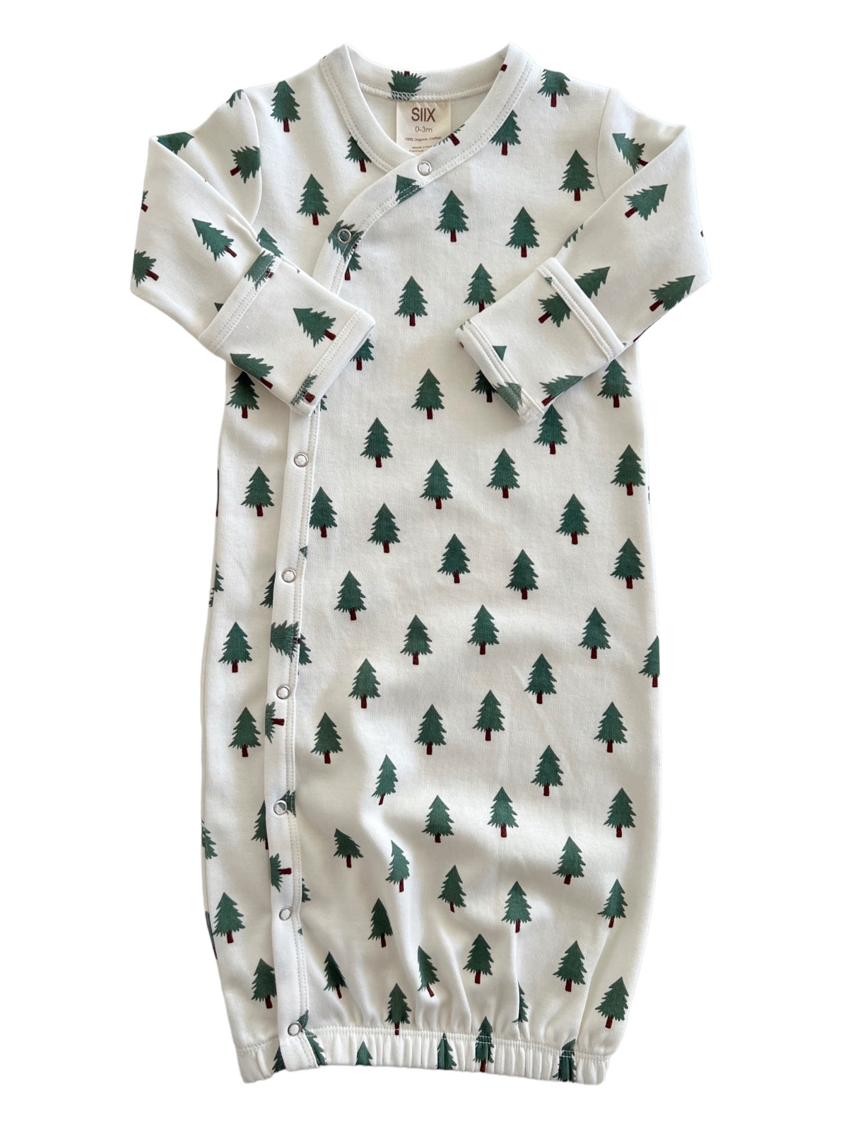 White newborn gown with green tree patterns, featuring snap buttons and elastic at the bottom.
