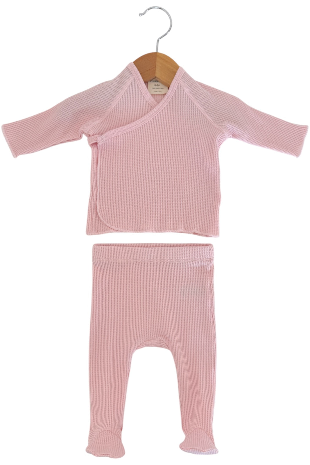 Pink baby outfit featuring a long-sleeve wrap top and matching leggings, displayed on a wooden hanger.