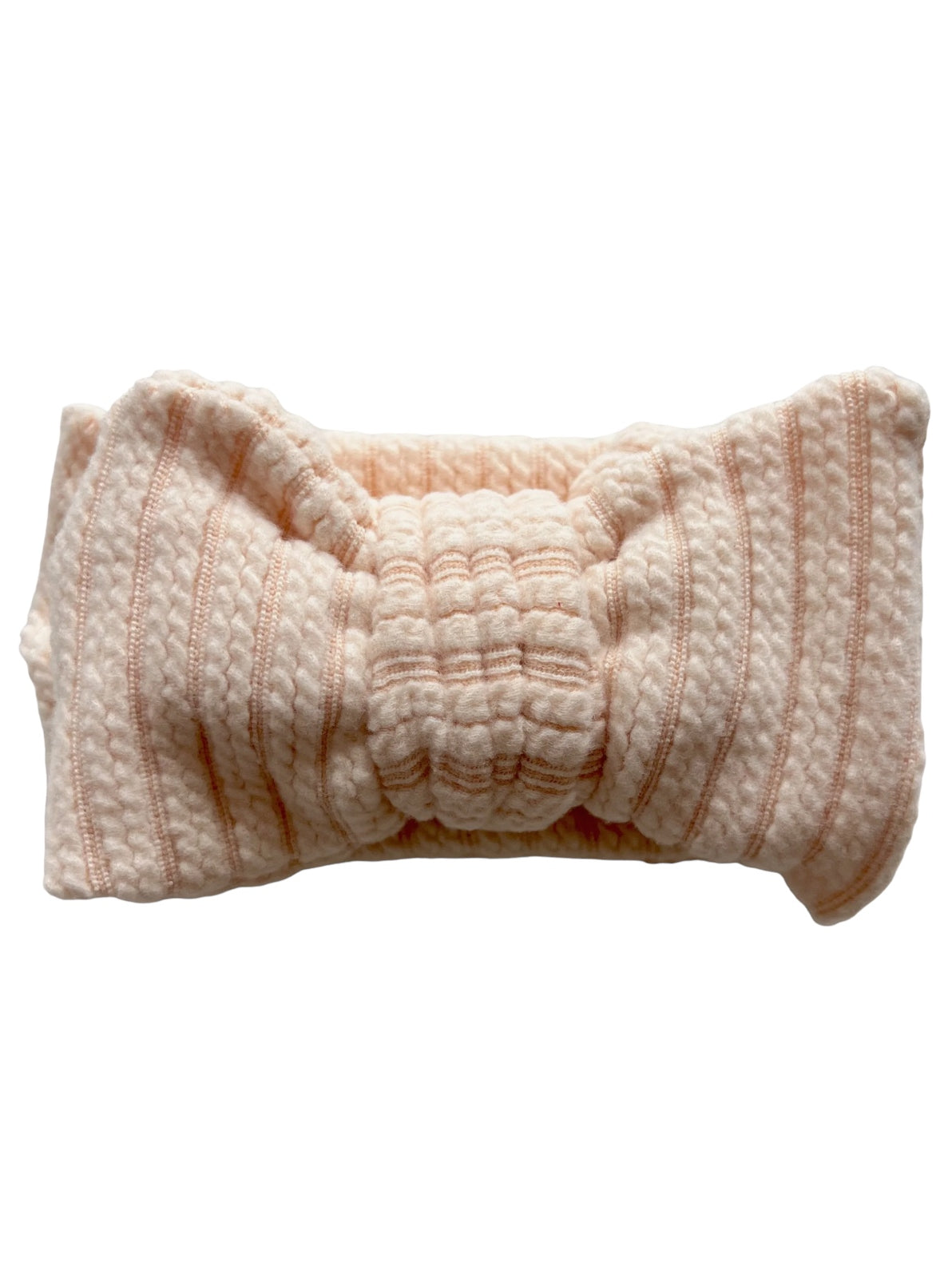 Light pink headband with textured fabric and a bow knot detail, featuring subtle vertical stripes.