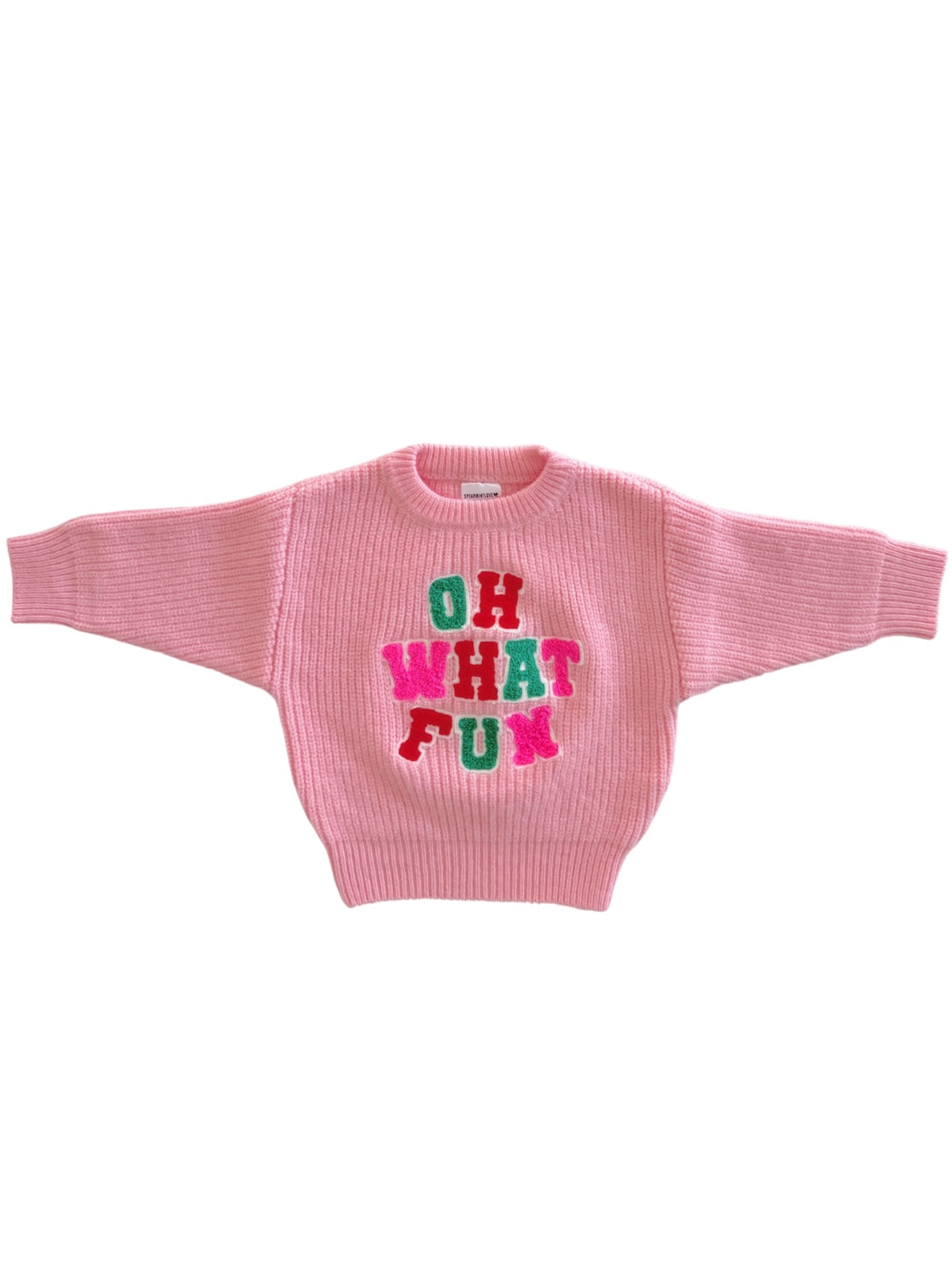 Pink sweater with oversized sleeves featuring the text "OH WHAT FUN" in colorful letters.