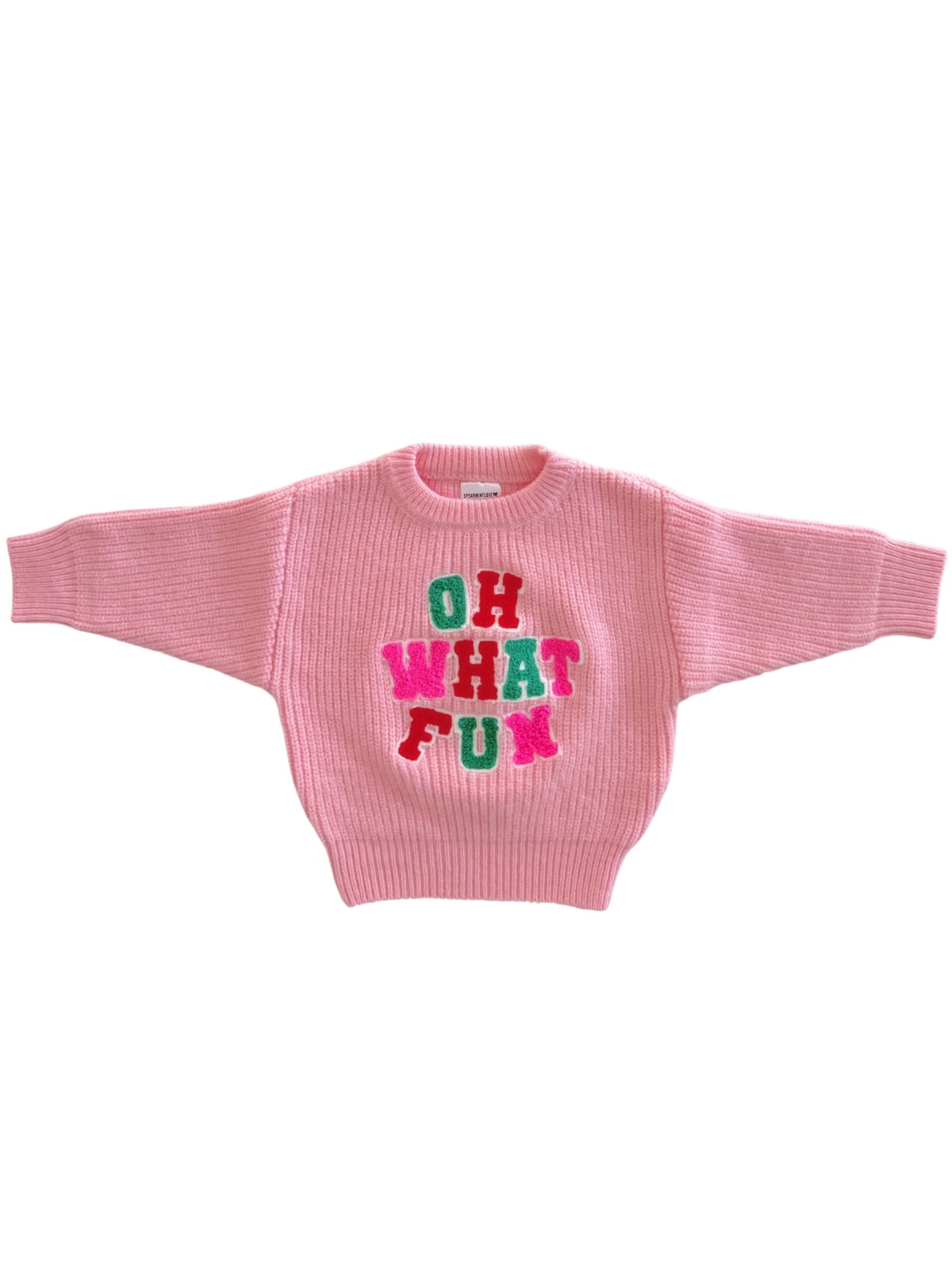 Pink sweater with oversized sleeves featuring the text "OH WHAT FUN" in colorful letters.