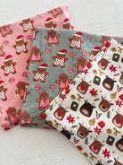 Three festive fabric swatches featuring gingerbread characters and reindeer in Christmas-themed patterns.