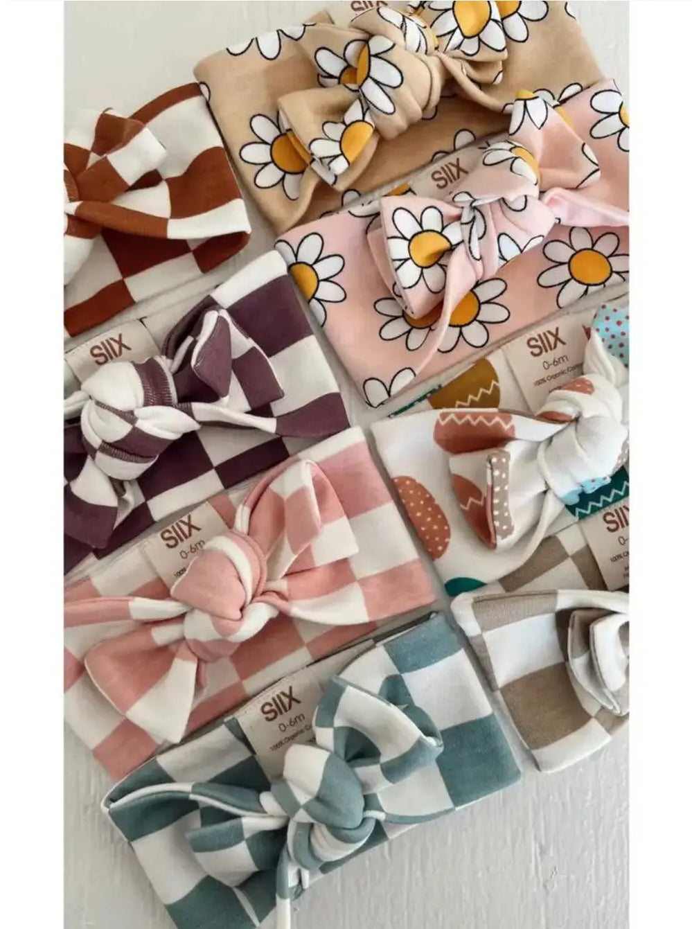 Assorted baby headbands featuring various colors and patterns, including florals and checks, displayed neatly.