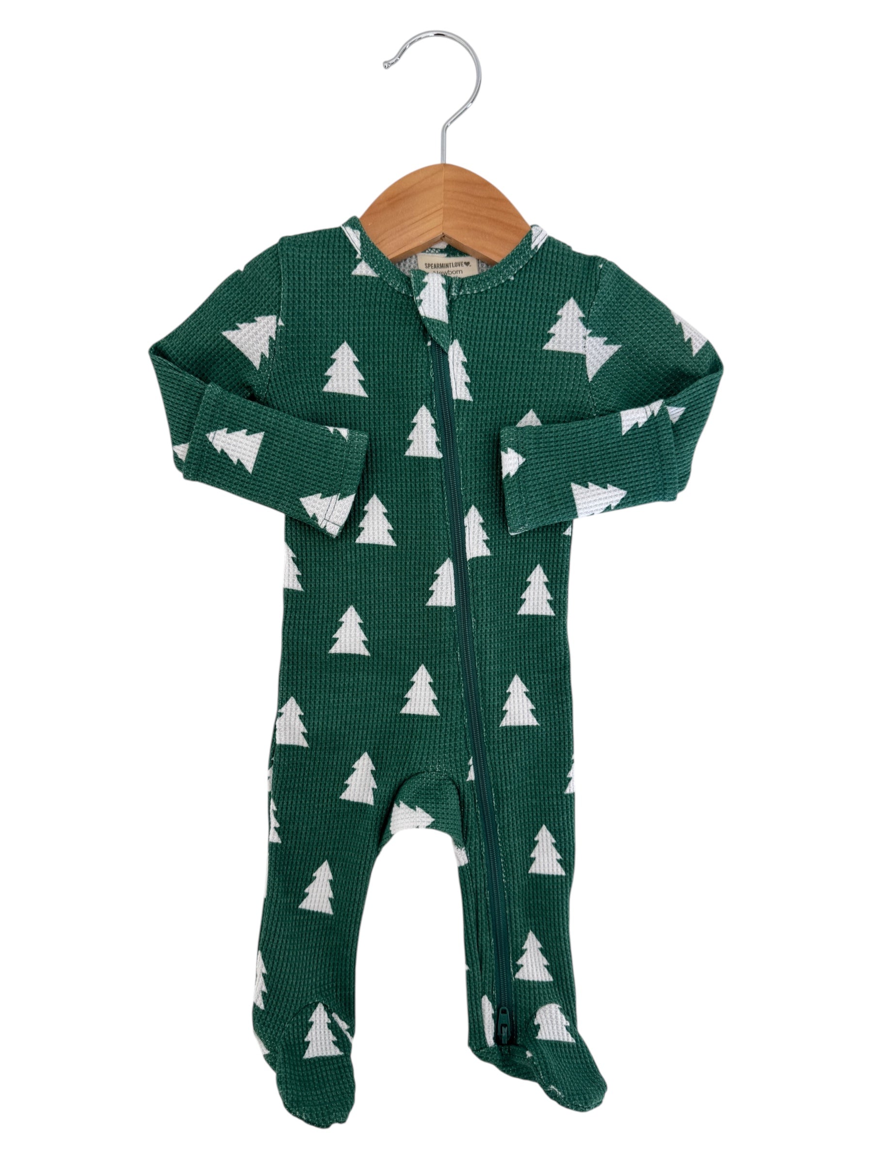 Green baby onesie with white Christmas tree pattern, featuring a front zipper and footed design.