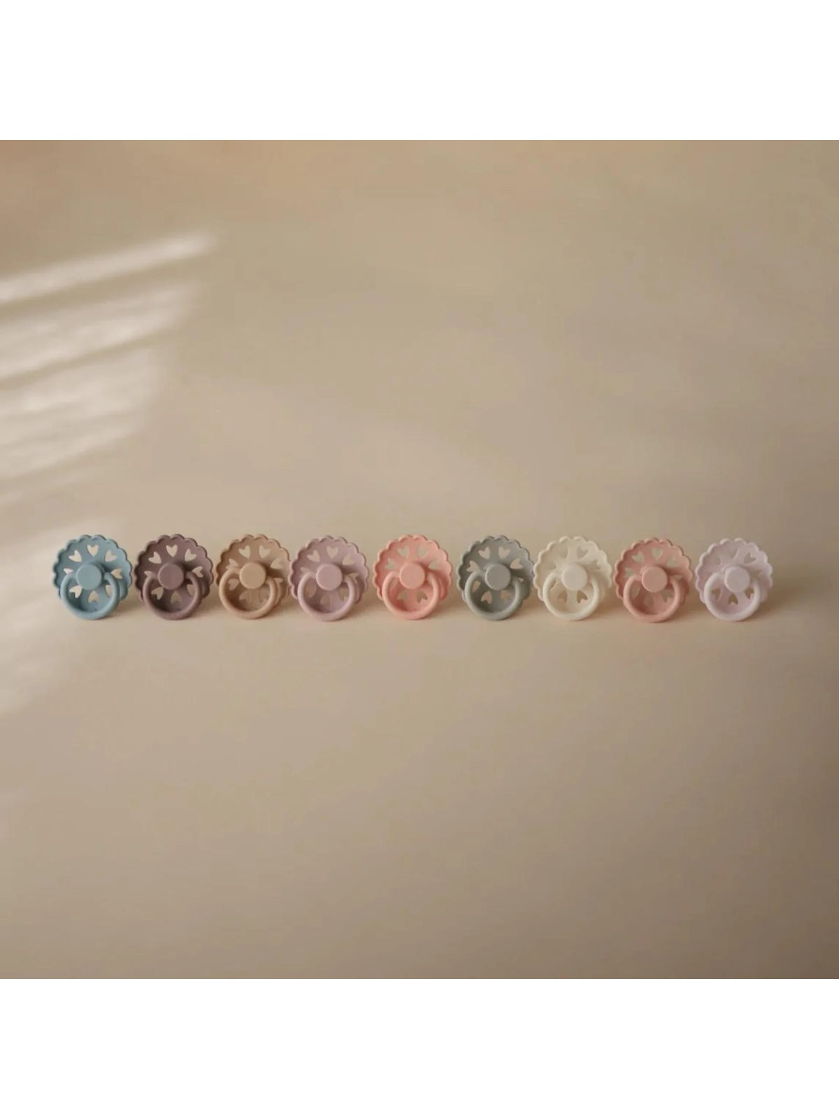 A row of pastel-colored hair clips on a neutral background, showcasing various floral designs.