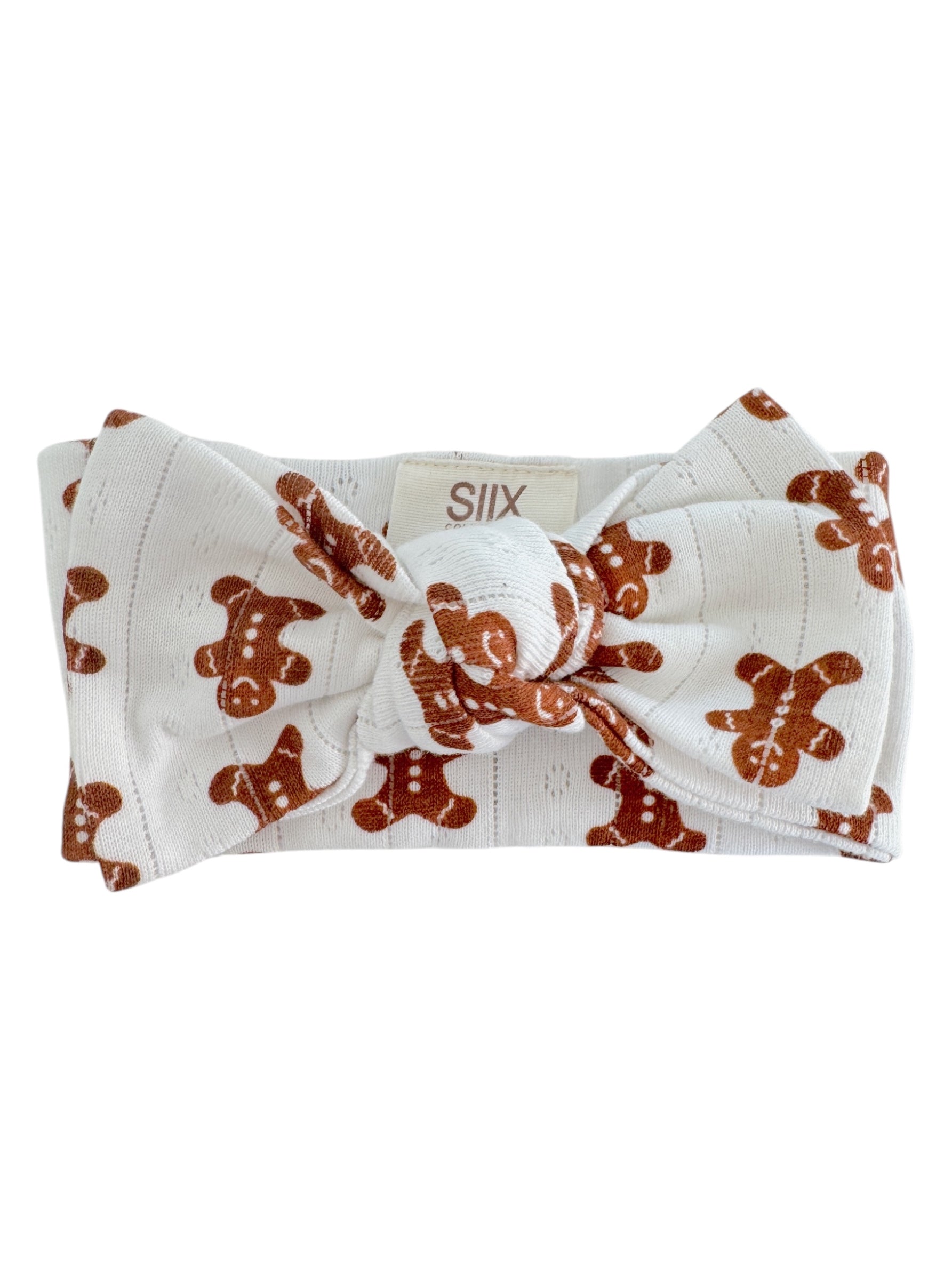 Gingerbread man print headband with a large bow on a white background.