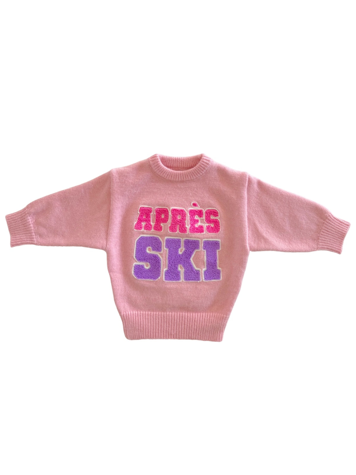 Pink sweater with “APRÈS SKI” in pink and purple text across the front, ribbed collar and cuffs.
