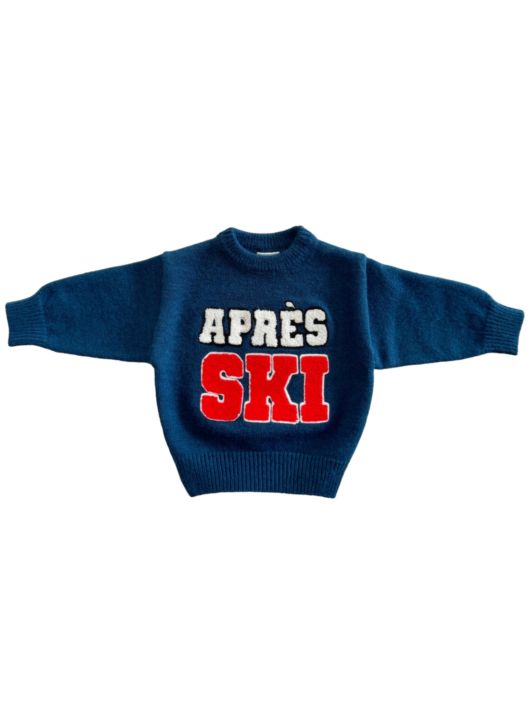 Blue knitted sweater with "APRÈS SKI" in bold white and red letters.