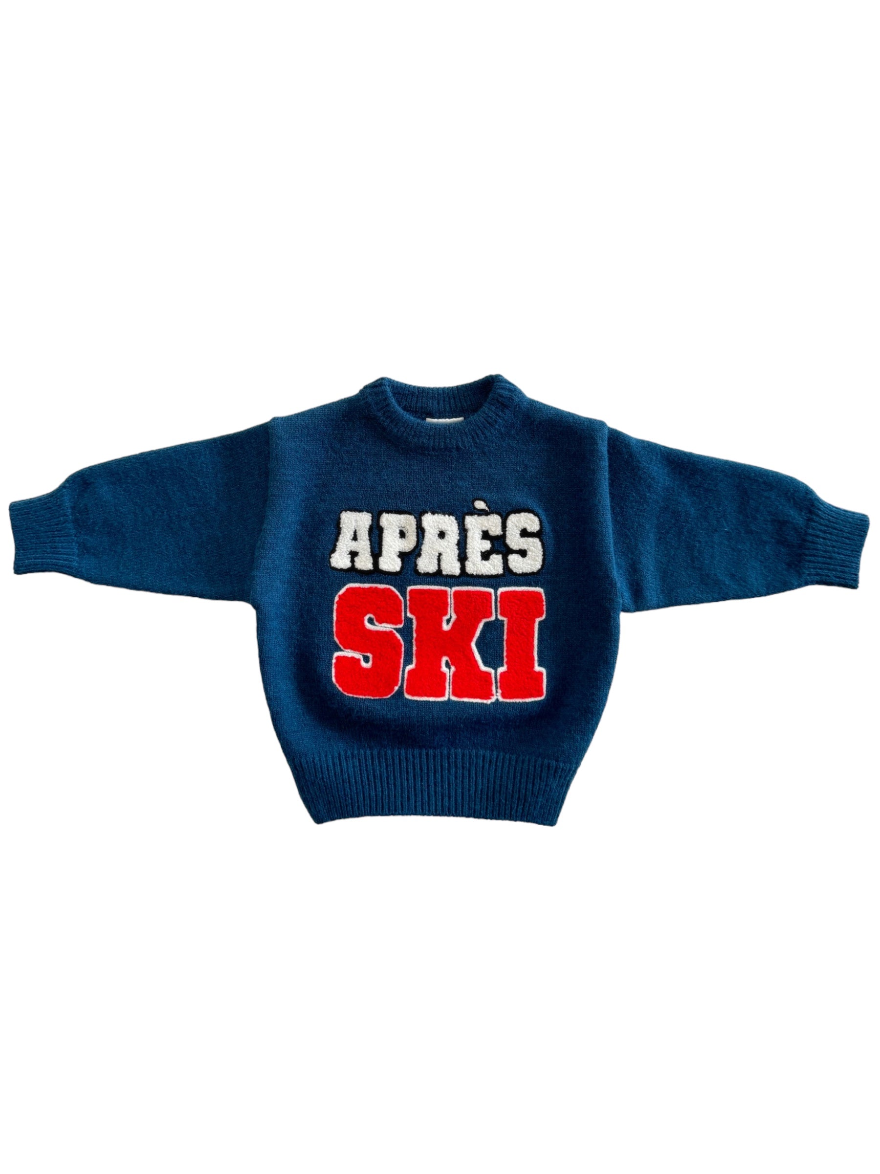 Blue knitted sweater with "APRÈS SKI" in bold white and red letters.