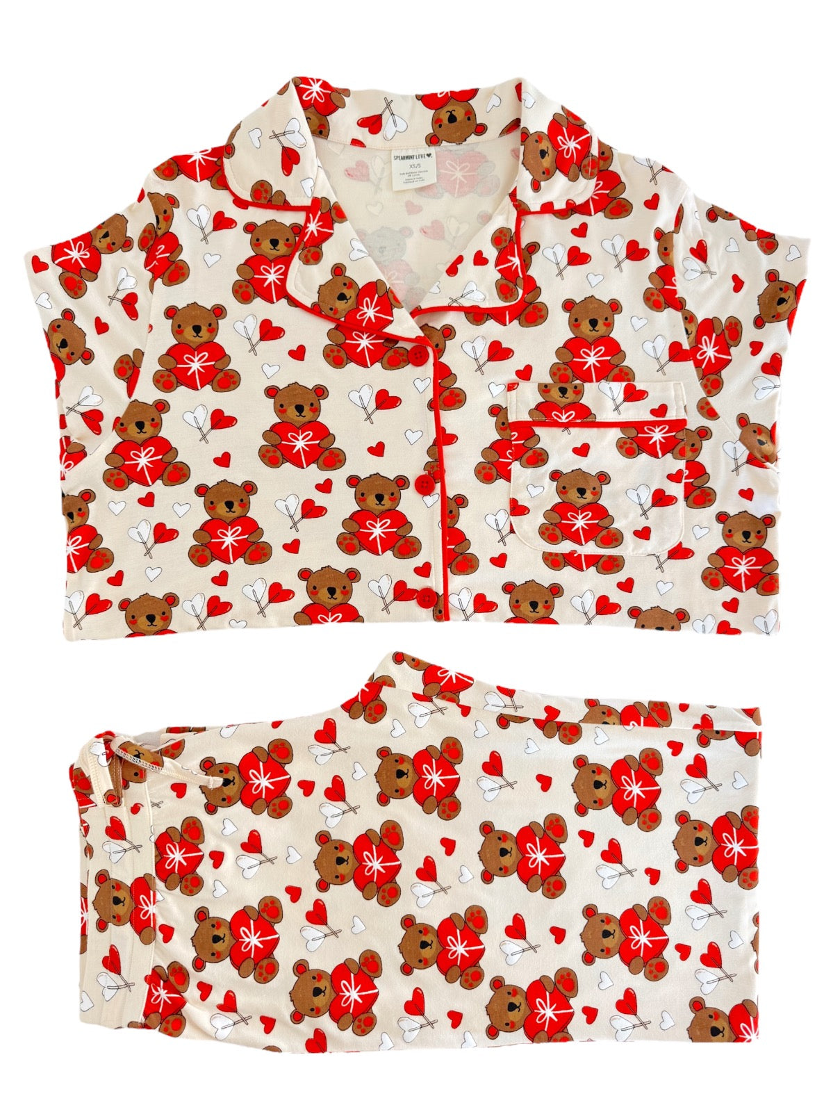 Cute pajama set featuring teddy bears and red hearts on a beige background, perfect for cozy nights.