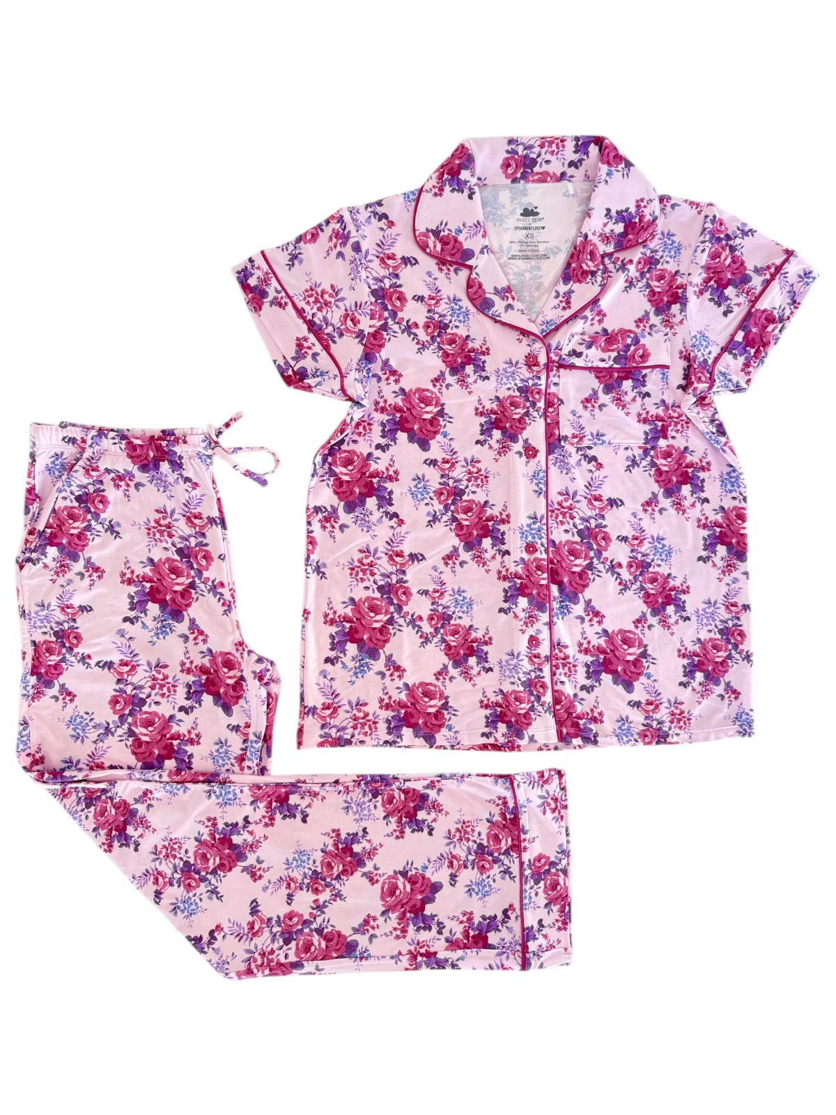 Floral pink pajama set featuring short-sleeve top and pants with blue and purple roses. Ideal for cozy nights.