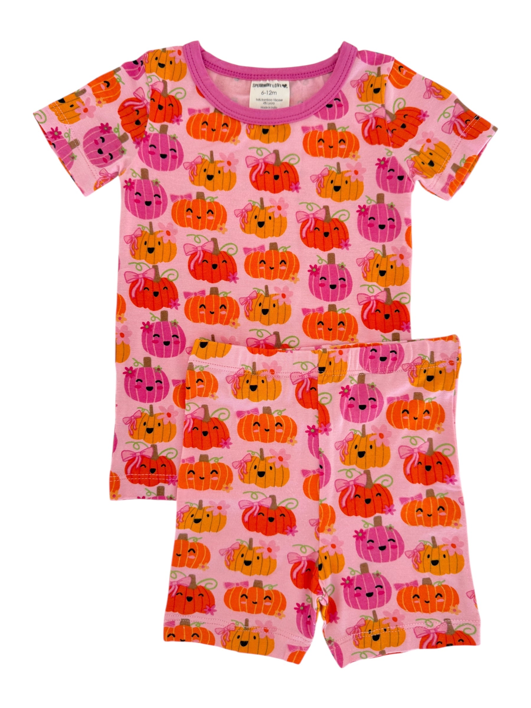 Pink pajama set featuring colorful, smiling pumpkins with bows, suitable for infants and toddlers.