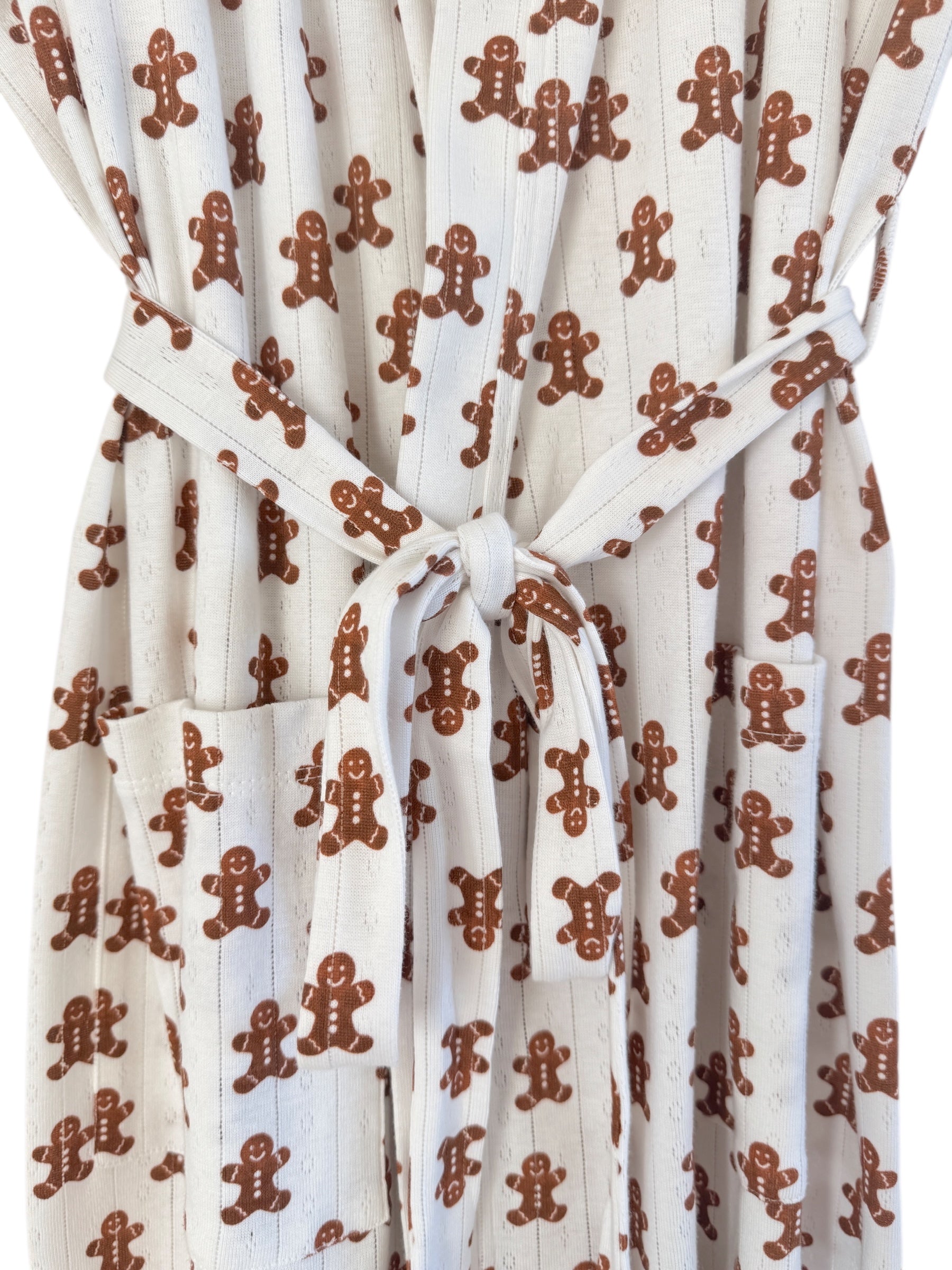 White robe with gingerbread man print, featuring a tied waist and pockets. Ideal for festive comfort.