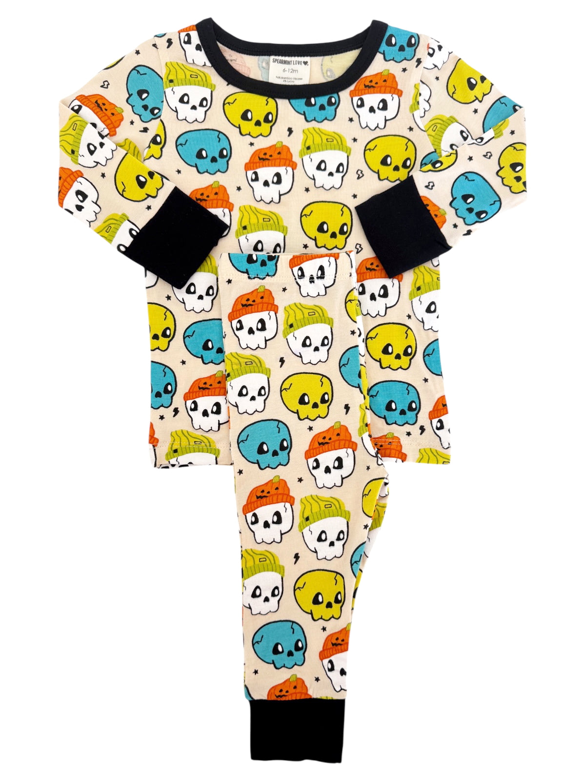 Kids' pajamas featuring colorful skull patterns in blue, yellow, orange, and green on a cream background.