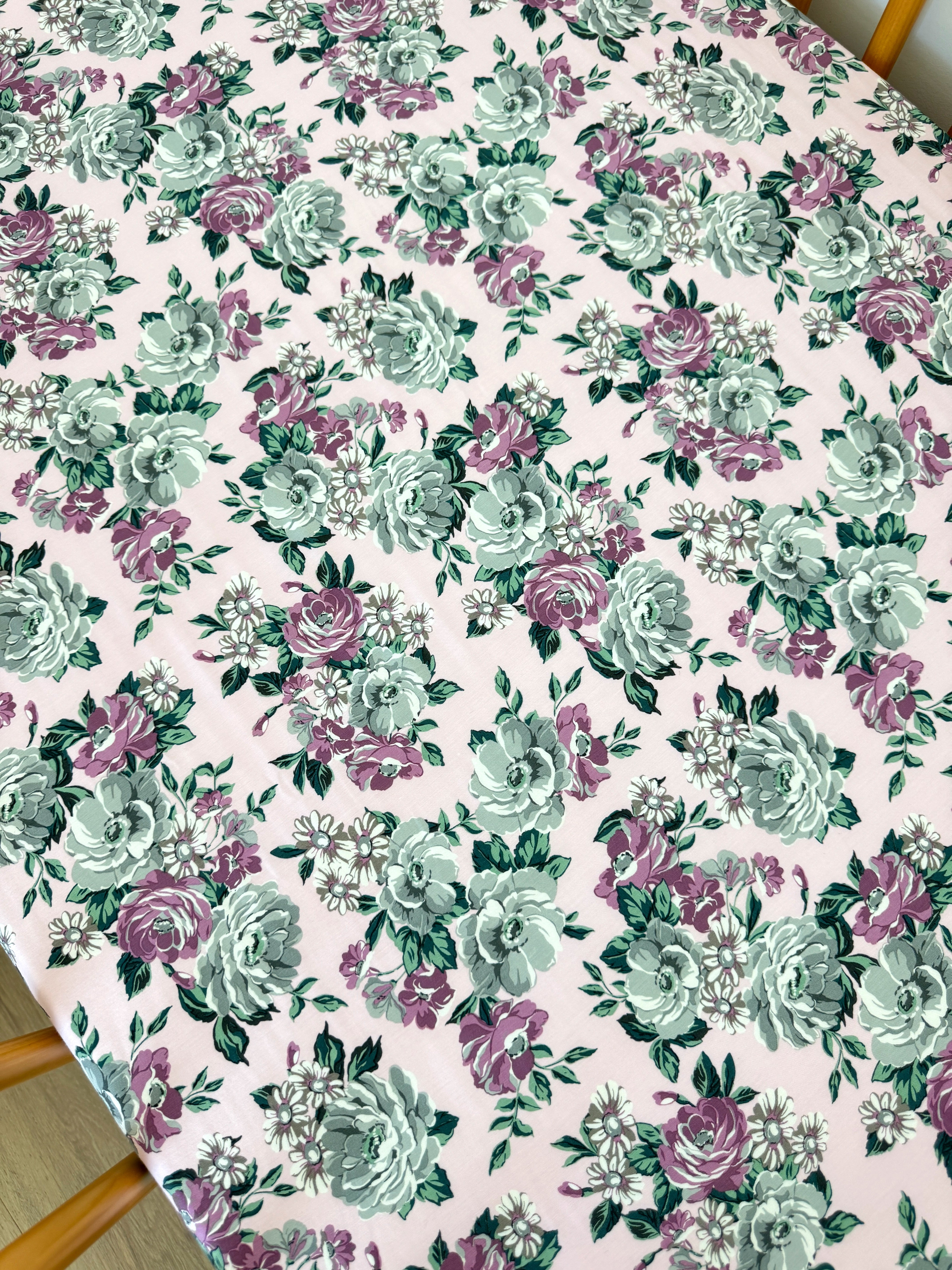 Floral pattern with roses and greenery on a pink background, perfect for home decor or textile designs.