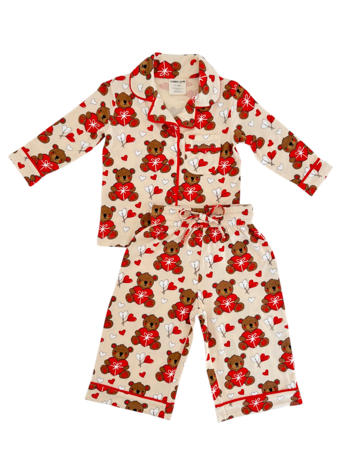 Children's pajama set featuring a playful bear and heart pattern in red, white, and beige colors.