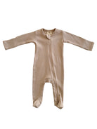 Beige ribbed baby onesie with long sleeves and a front zipper, designed for comfort and ease.