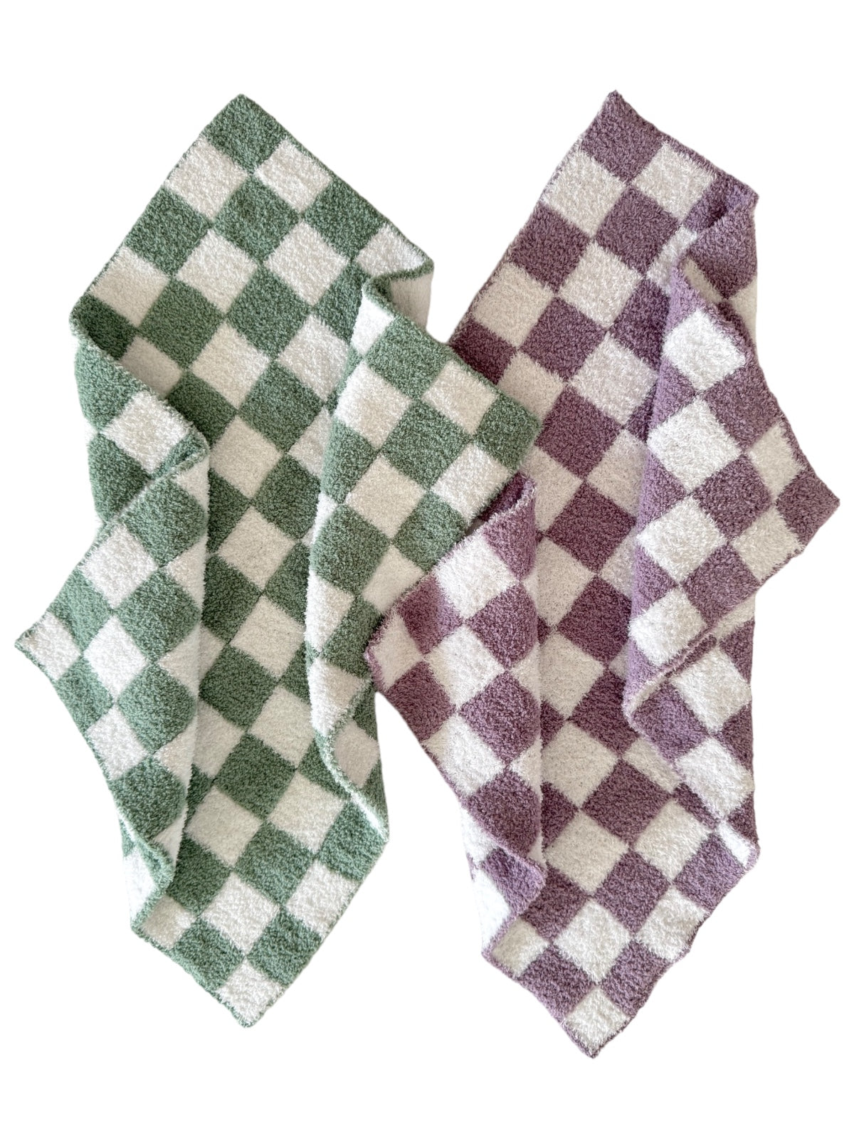 Two checkered dish towels in green and purple, folded with white accents showcasing a cozy kitchen aesthetic.