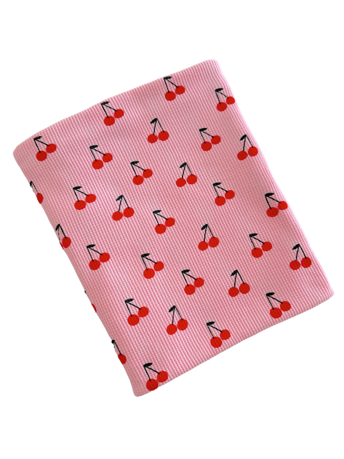 Pink fabric featuring a repeating pattern of red cherries with green stems.