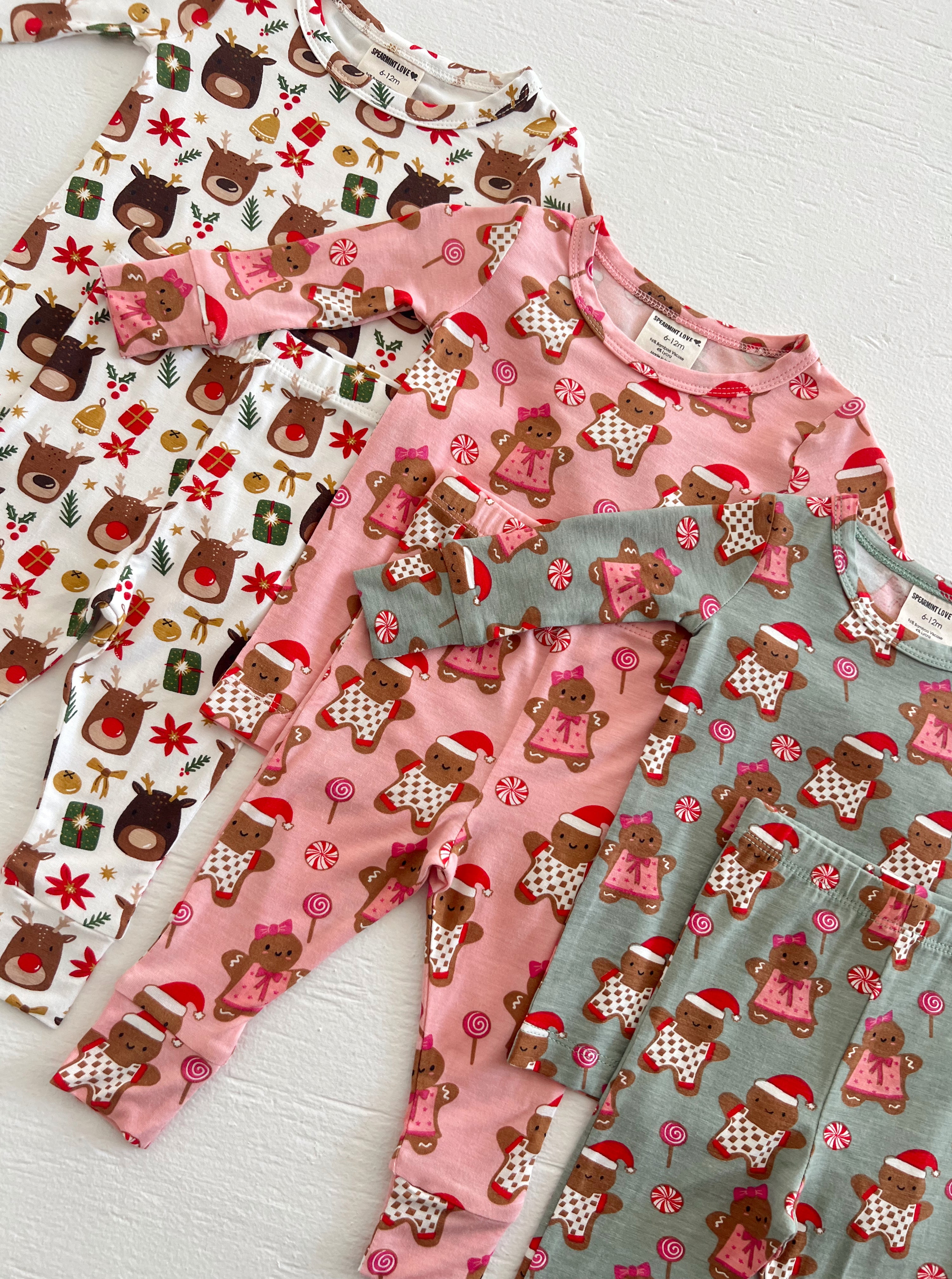 Colorful children's pajamas with holiday themes, featuring reindeer and gingerbread designs.