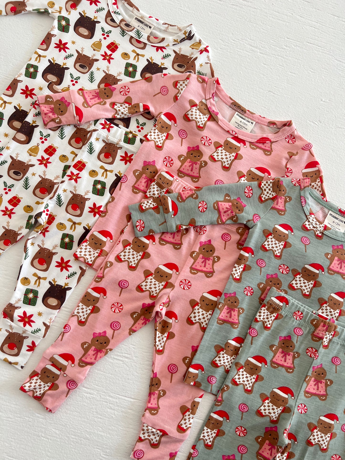 Colorful children's pajamas with holiday themes, featuring reindeer and gingerbread designs.