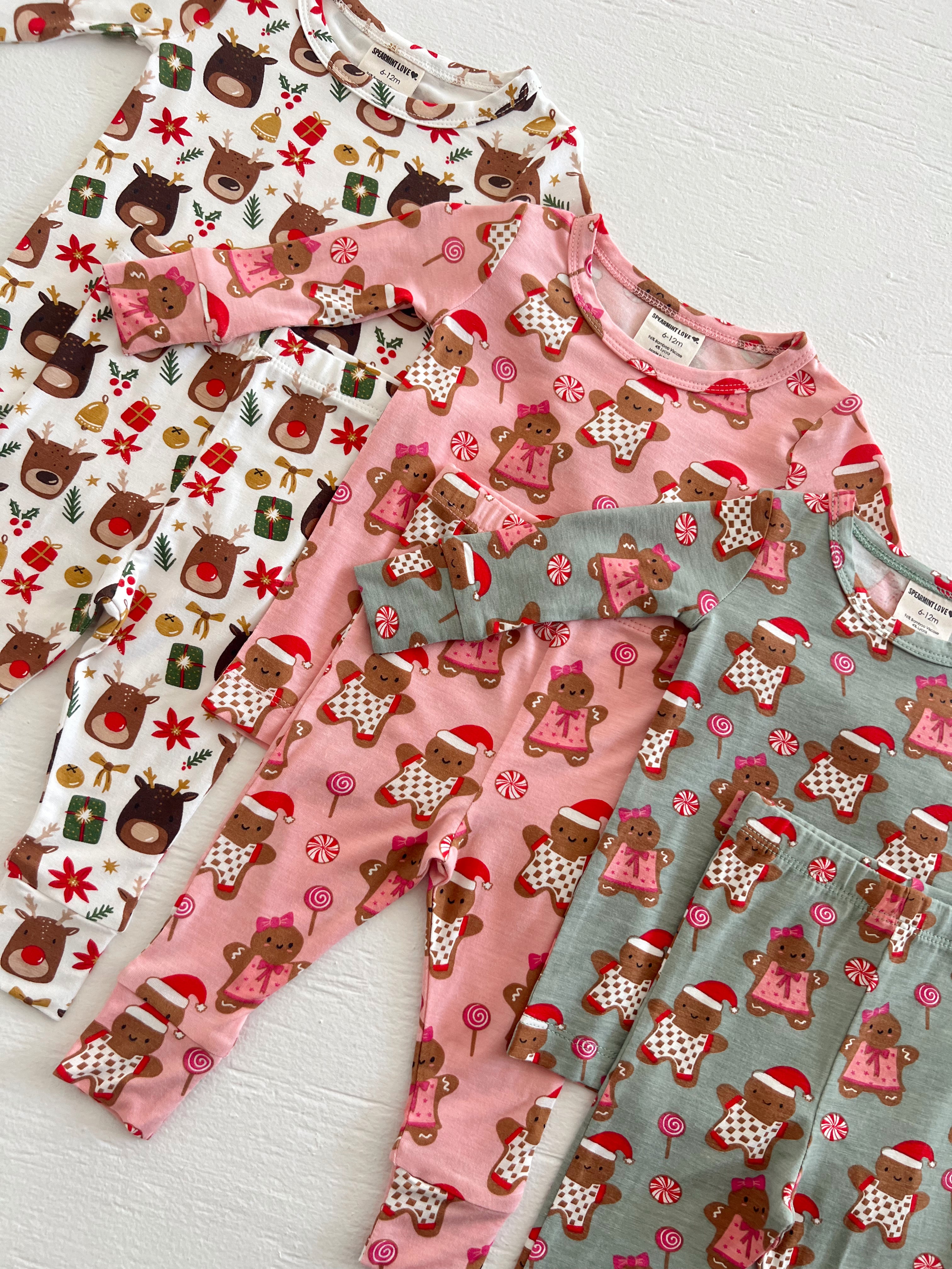 Colorful children's pajamas with holiday themes, featuring reindeer and gingerbread designs.