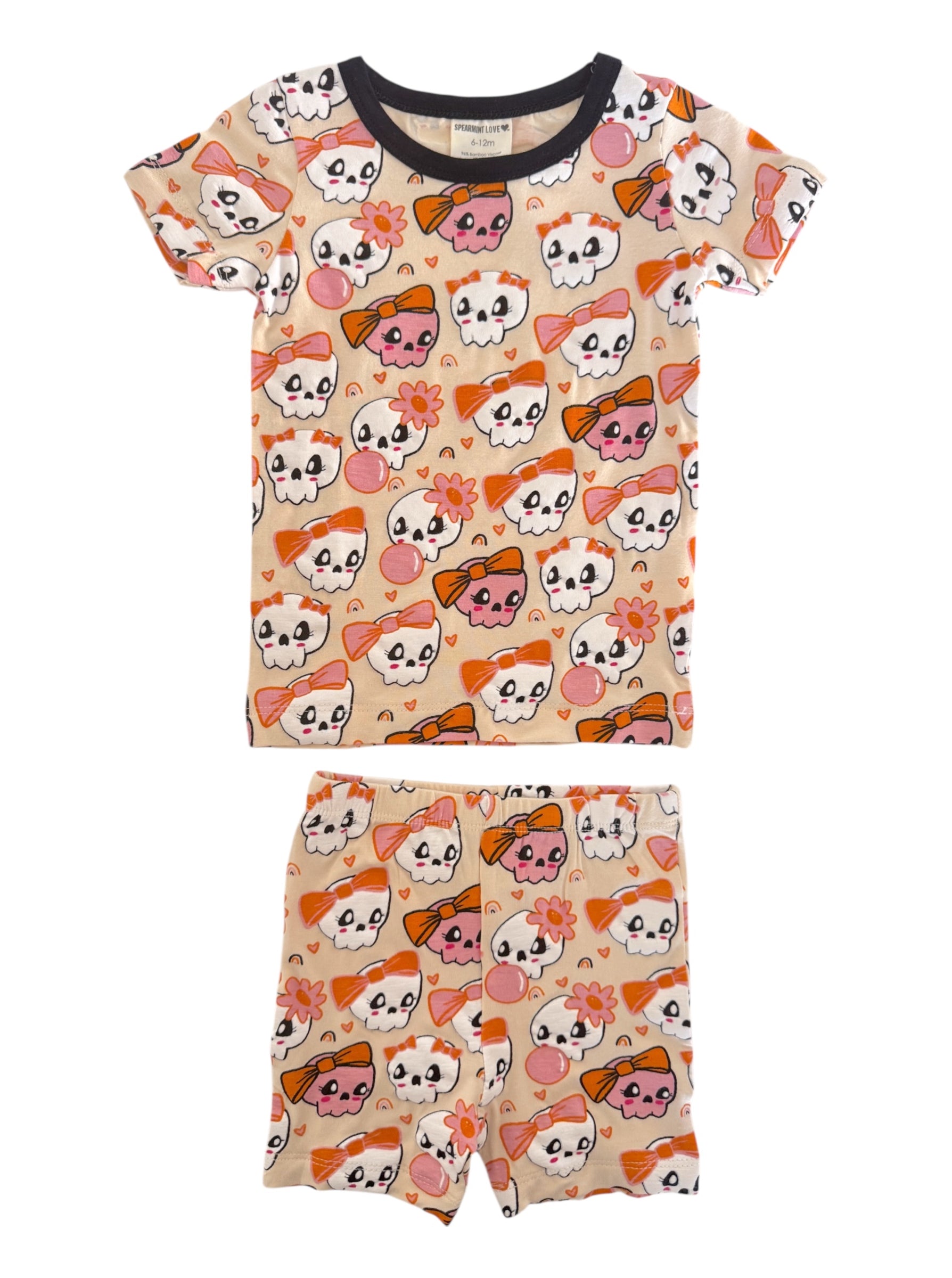 Kids' pajamas set featuring playful skull and bow patterns in bright colors, ideal for sleepwear or lounging.