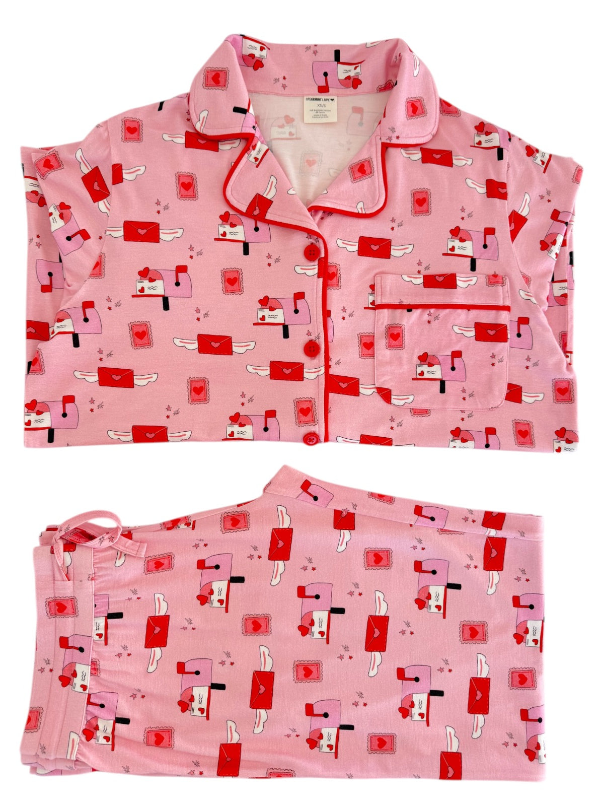 Pink pajama set featuring a playful pattern of mailboxes and hearts, including a top and matching pants.