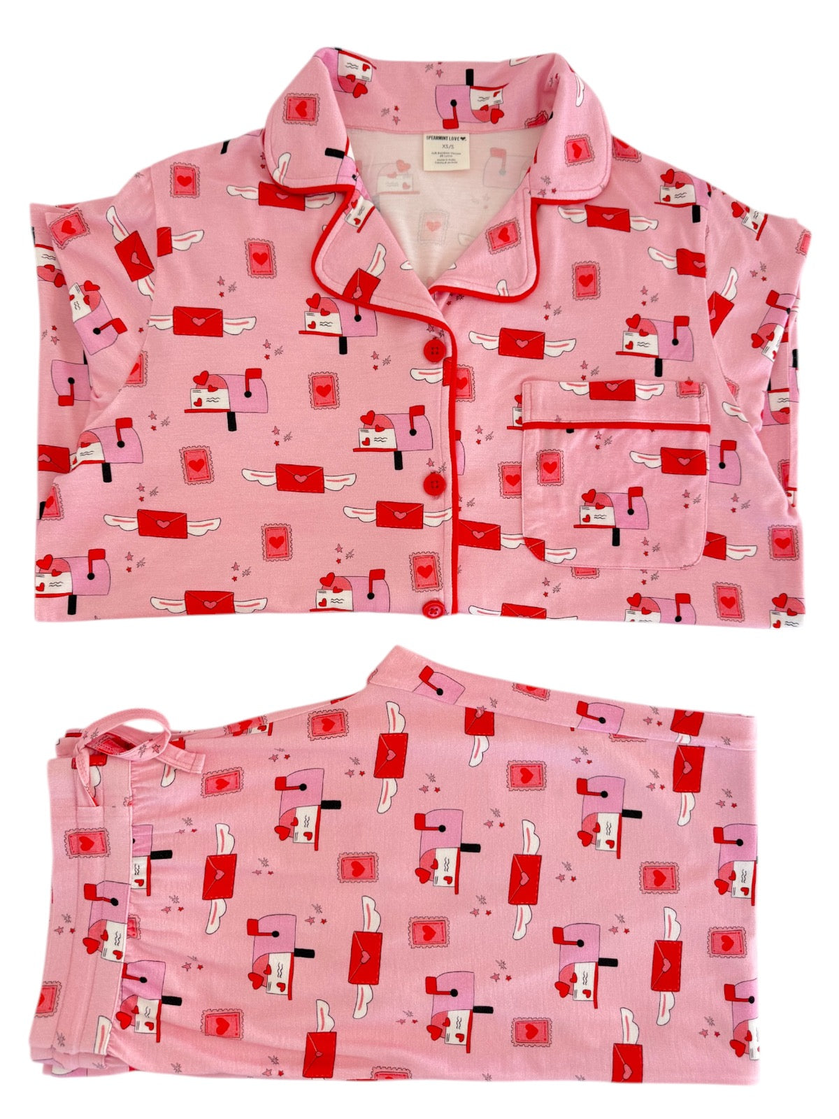 Pink pajama set featuring a playful pattern of mailboxes and hearts, including a top and matching pants.