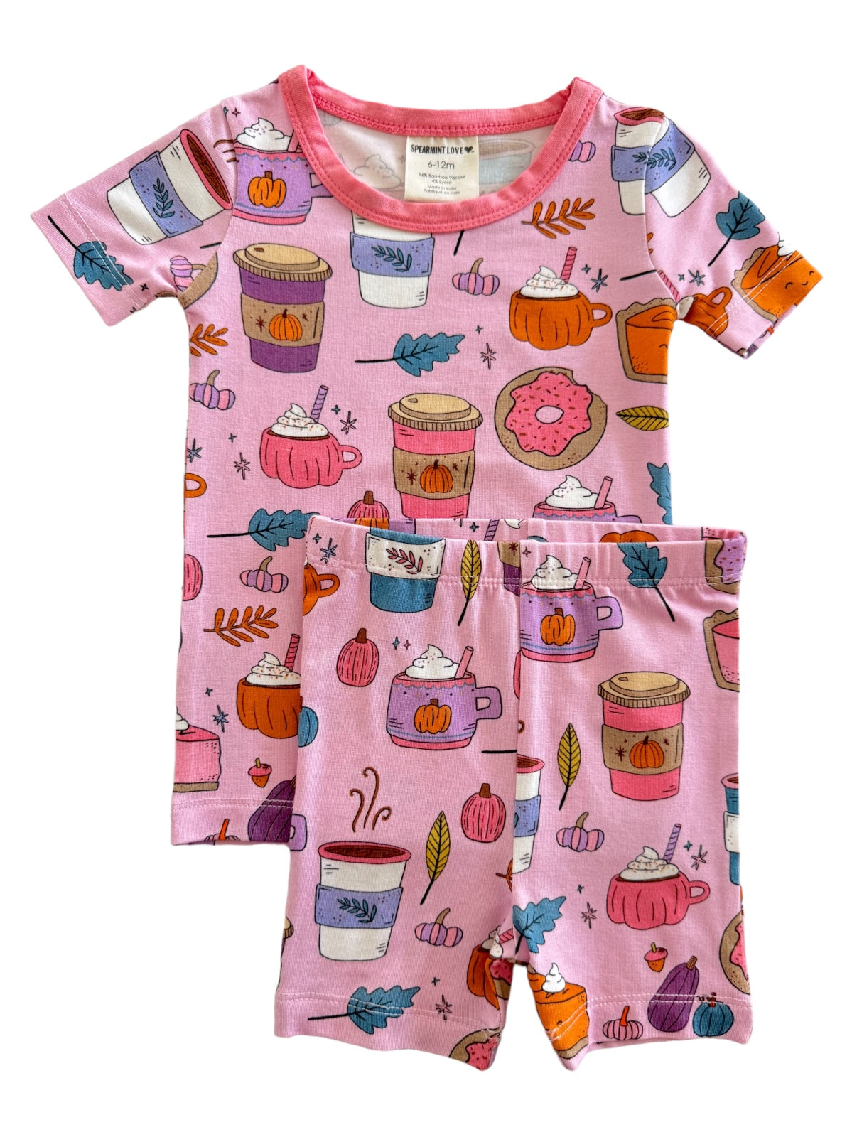Pink children’s pajamas featuring playful patterns of beverages, pumpkins, and donuts.
