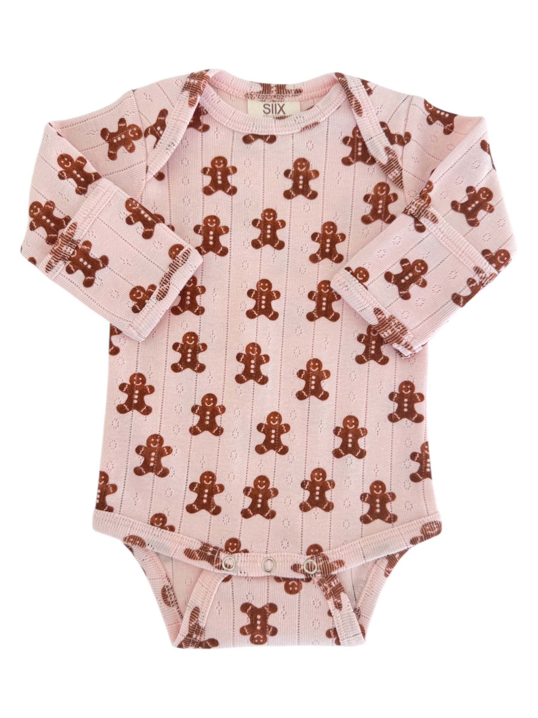 Pink baby onesie with a gingerbread man pattern on soft fabric. Long sleeves and snap closures at the bottom.